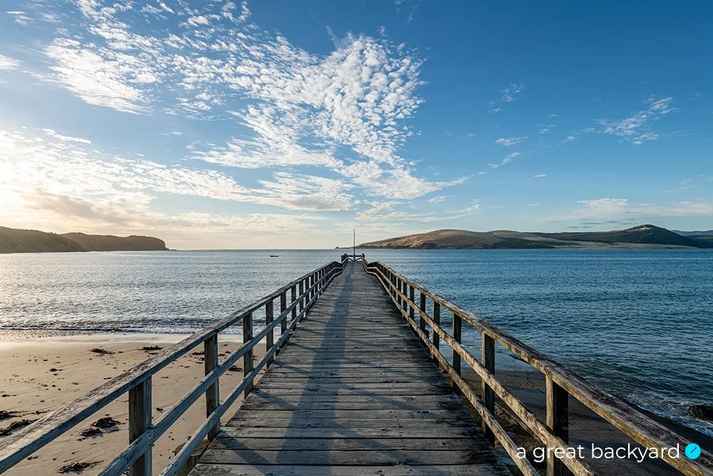View down Hokianga pier under a blue sky, Northland, New Zealand
