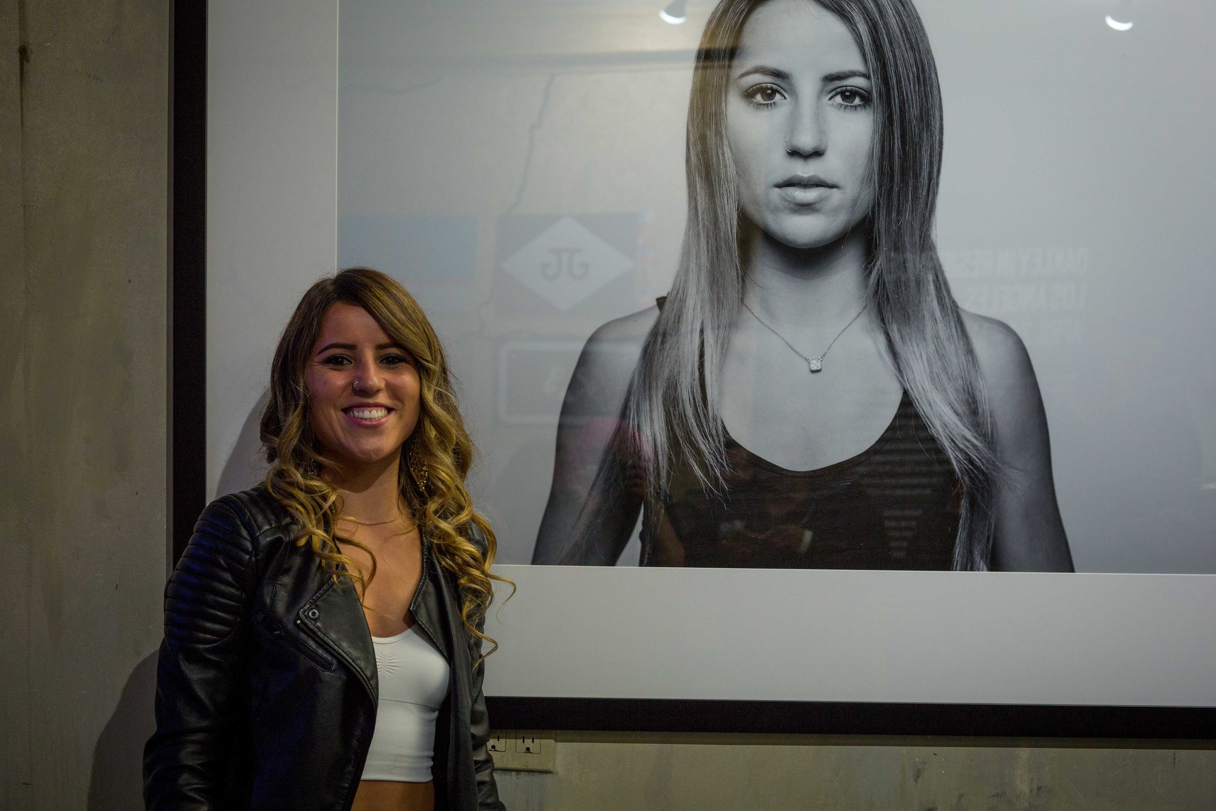 Leticia Bufoni next to her exhibition portrait.