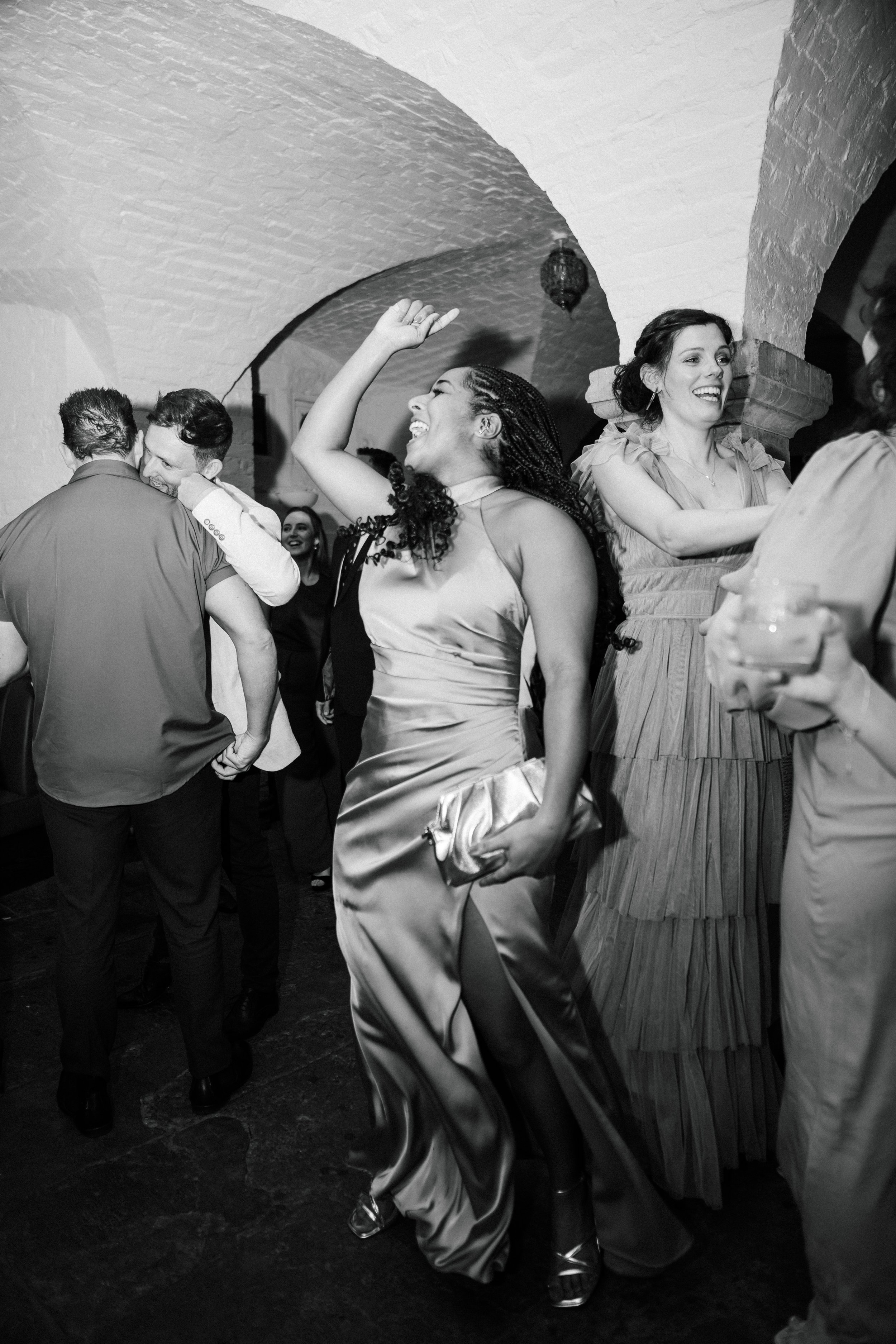 People dancing and socializing at a party, smiling and having fun.