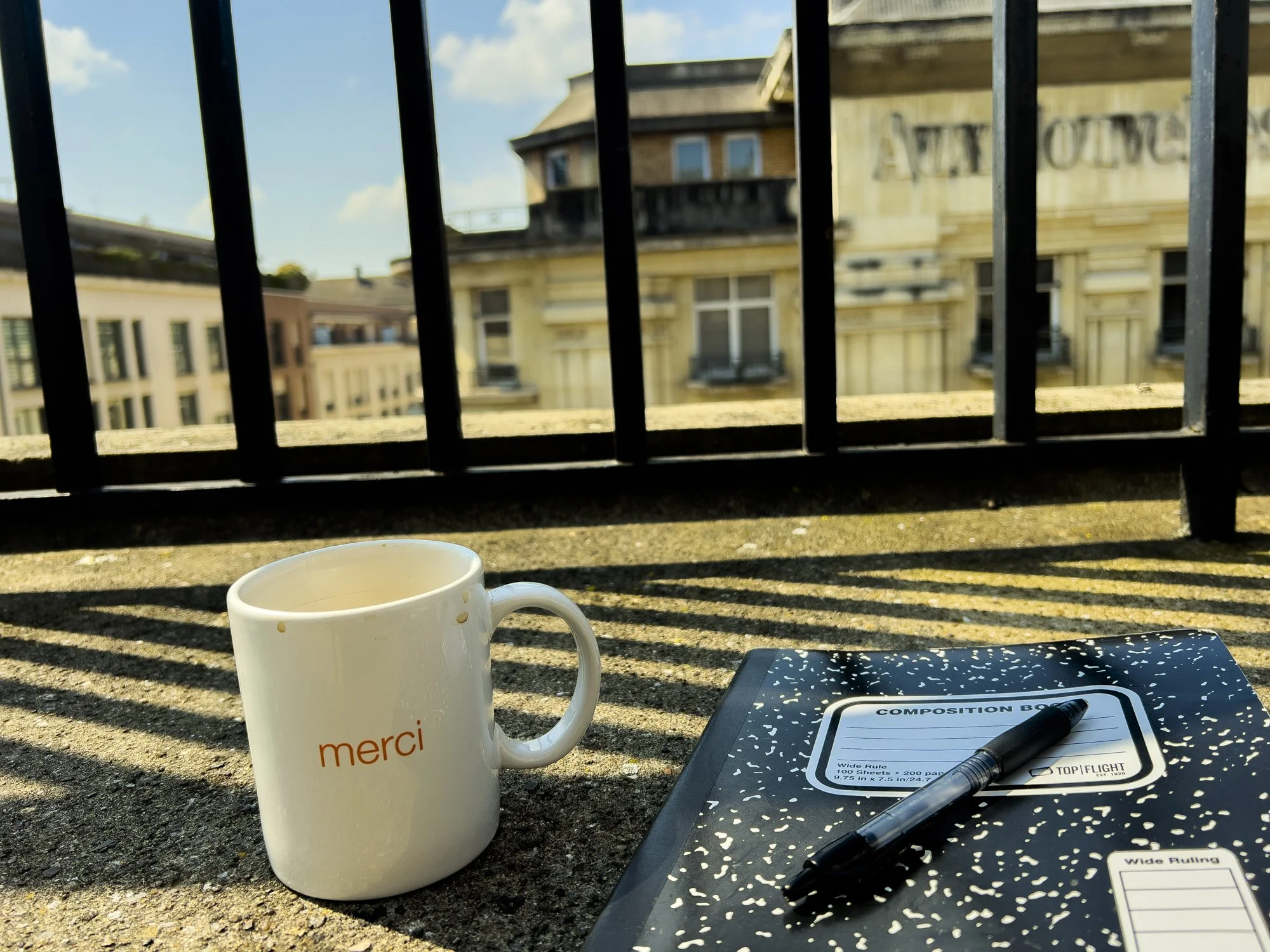 Merci cup and notebook on balcony.jpg