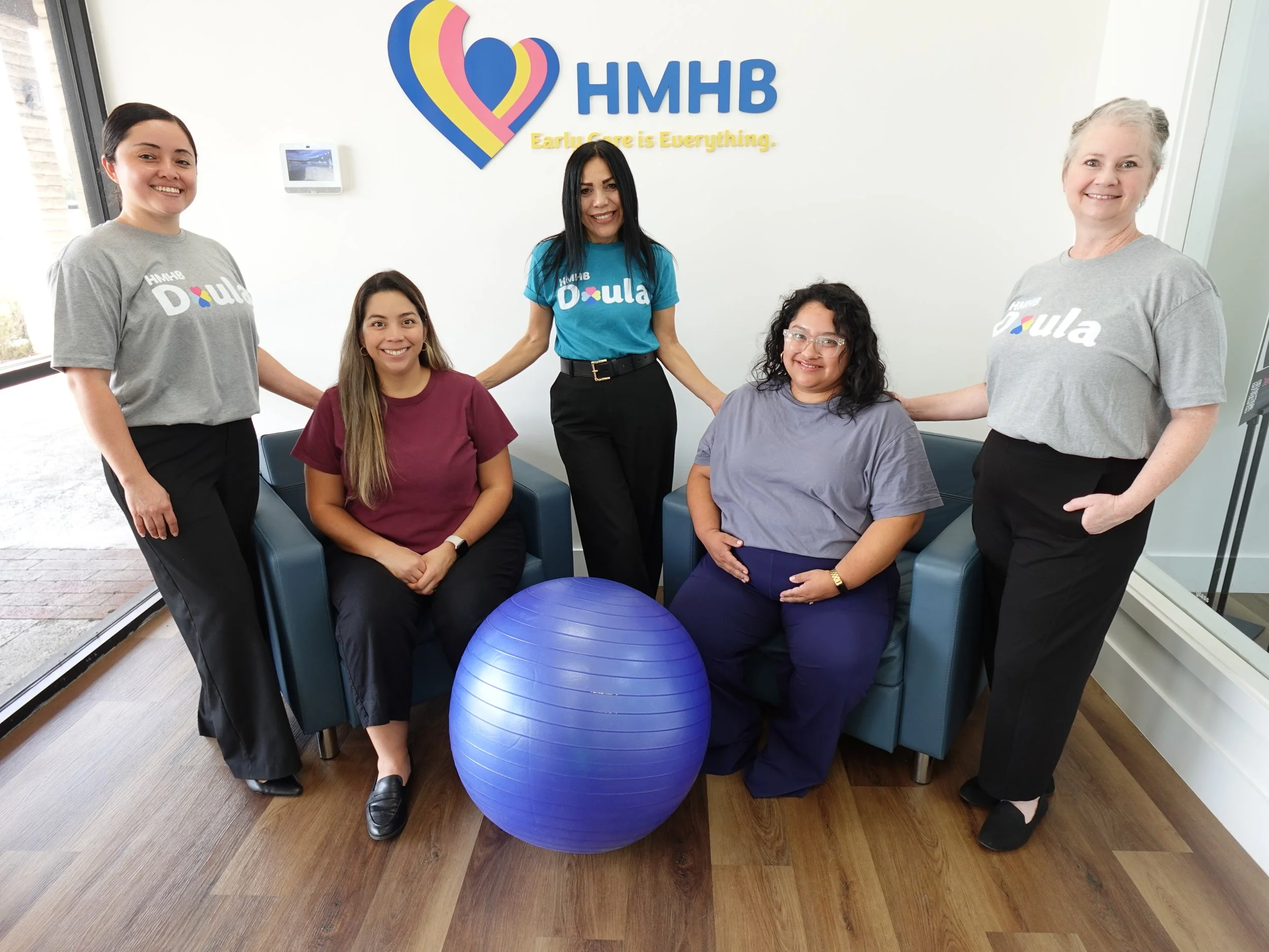 Stronger Together Doulas posing with clients in the HMHB office