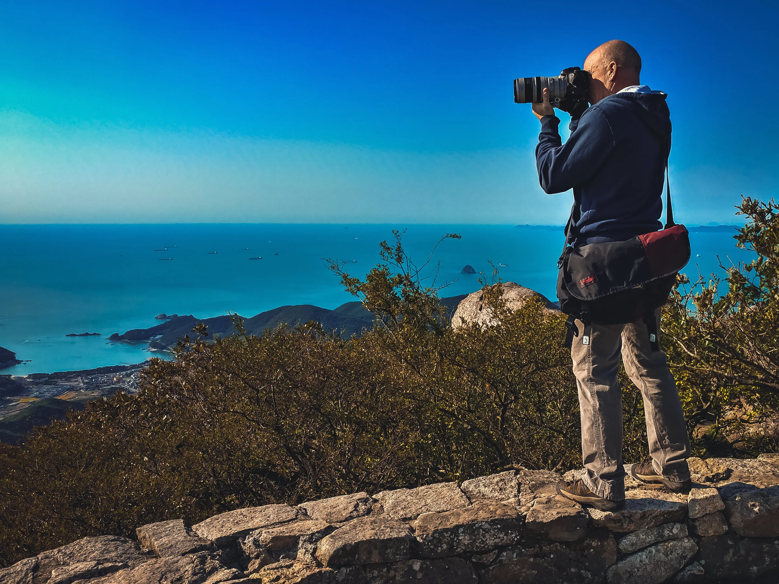 Tom photographing the South Korean seascape from atop Geumsan Mountain at a Buddhist Temple known as Boriam Hermitage. (Photo Credit - Kathryn Burns Oliver, 2018)