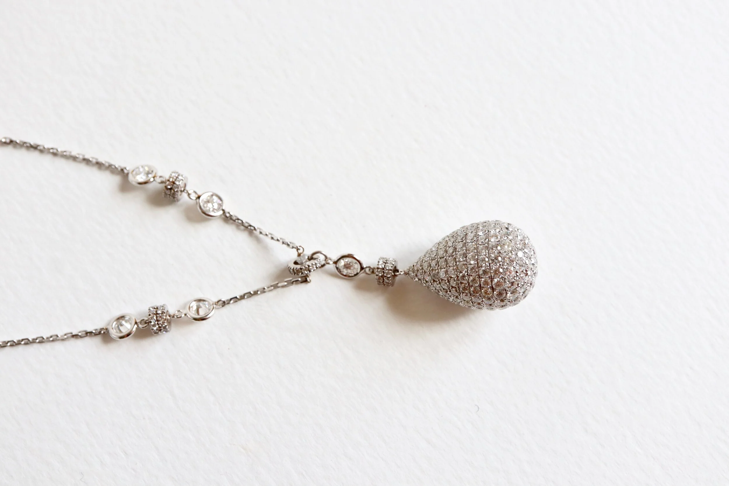 Pendentif goutte en or blanc 18 carats sertissant des diamants avec sa chaîne. 
