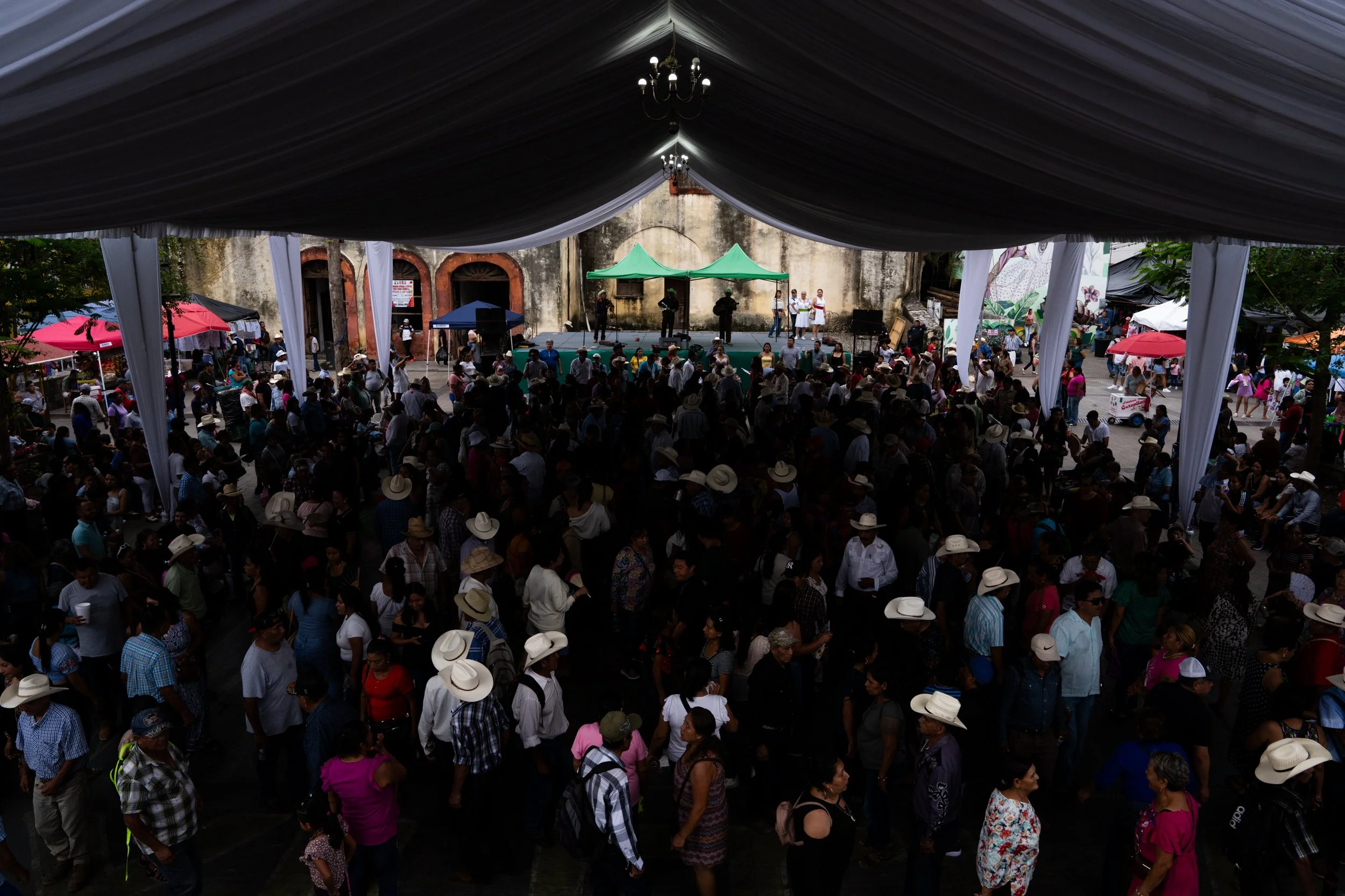 People gather for Los Domingos de Huapango in the central plaza in Xilitla, San Luis Potosí, Mexico, on July 2026. Every Sunday, musicians play the traditional regional music known as Son Huasteco, while a large tarima (wooden platform) fills the dow