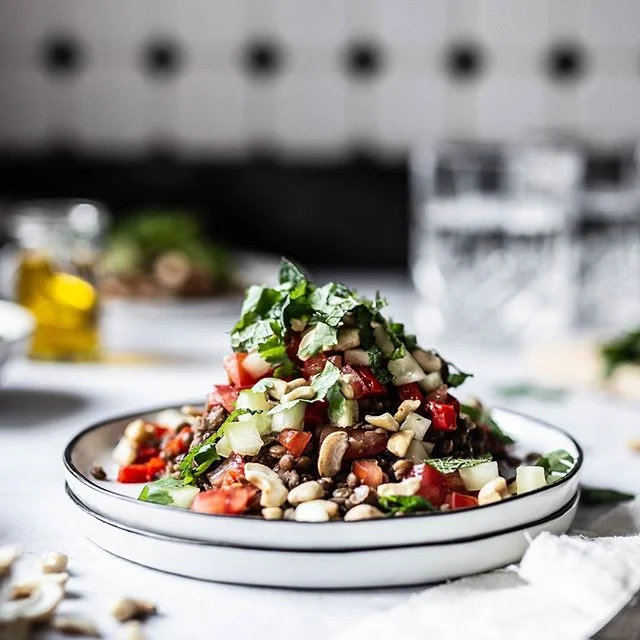 (Werbung/Verlinkung) Linsen und Kichererbsen sind zwei unserer absoluten Favoriten 😊. Für @koro_de haben wir zwei tolle Rezepte mit diesen vielfältig einsetzbaren Sattmachern vorbereitet. Heute starten wir mit Linsen, die wir zusammen mit ofengerösteten Paprika, Tomaten, Gurken und der Gewürzmischung Ras el Hanout in einen wunderbaren lauwarmen Salat verwandelt haben. Und für den Extra Crunch gab es noch etwas Cashew-Bruch als Topping oben drauf. 🥗🌶🥒🍅⠀
⠀
👉 Foodstyling: frische Kräuter für das gewisse Etwas⠀
⠀
Um unseren Linsensalat auf dem Foto möglichst appetitlich aussehen zu lassen, haben wir jede einzelne Zutat des Salates ganz bewusst platziert. Damit auch wirklich jedes Stück Gurke und Tomate seinen richtigen Platz findet, kam hier auch wieder unsere Pinzette zum Einsatz. ⠀
⠀
Da insbesondere Kräuter wirklich schnell verwelken und dann nicht mehr schön aussehen, platzieren wir Kräuter erst ganz am Ende. Außerdem arbeiten wir am liebsten mit Kräutertöpfen für maximale Frische. Alternativ wickeln wir abgeschnittene Kräuter bis zur Verwendung schonmal in ein feuchtes Küchentuch ein, denn auch so bleiben sie länger frisch. 😊⠀
.⠀
.⠀
.⠀
📷 Canon EOS 6D / 50mm / ISO 250 / f/2,0 / 1/100⠀
.⠀
.⠀
.⠀
.⠀
.⠀
.⠀
#herbstrezept #herbstküche #linsensuppe⠀
#korolicious #gesunderezepte #gesundundlecker #gesundessen #gesundeernährung #zuckerfrei #ohnezucker #ballaststoffe #gesundeküche #organicfood #linsen #vegandeutschland #vegangermany #raselhanout #vegetarisch #orientalisch #stilllifegallery #cookmagazine #foodstylingandphotography #foodinspirations #foodstyleguide #vscfood #persianfood #thrivemags #essenundtrinken #foodblogliebe #rezeptideen⠀
@Foodandwine @lecker_magazin @brigittemagazin @essenundtrinken_magazin @livingathome_magazin ⠀