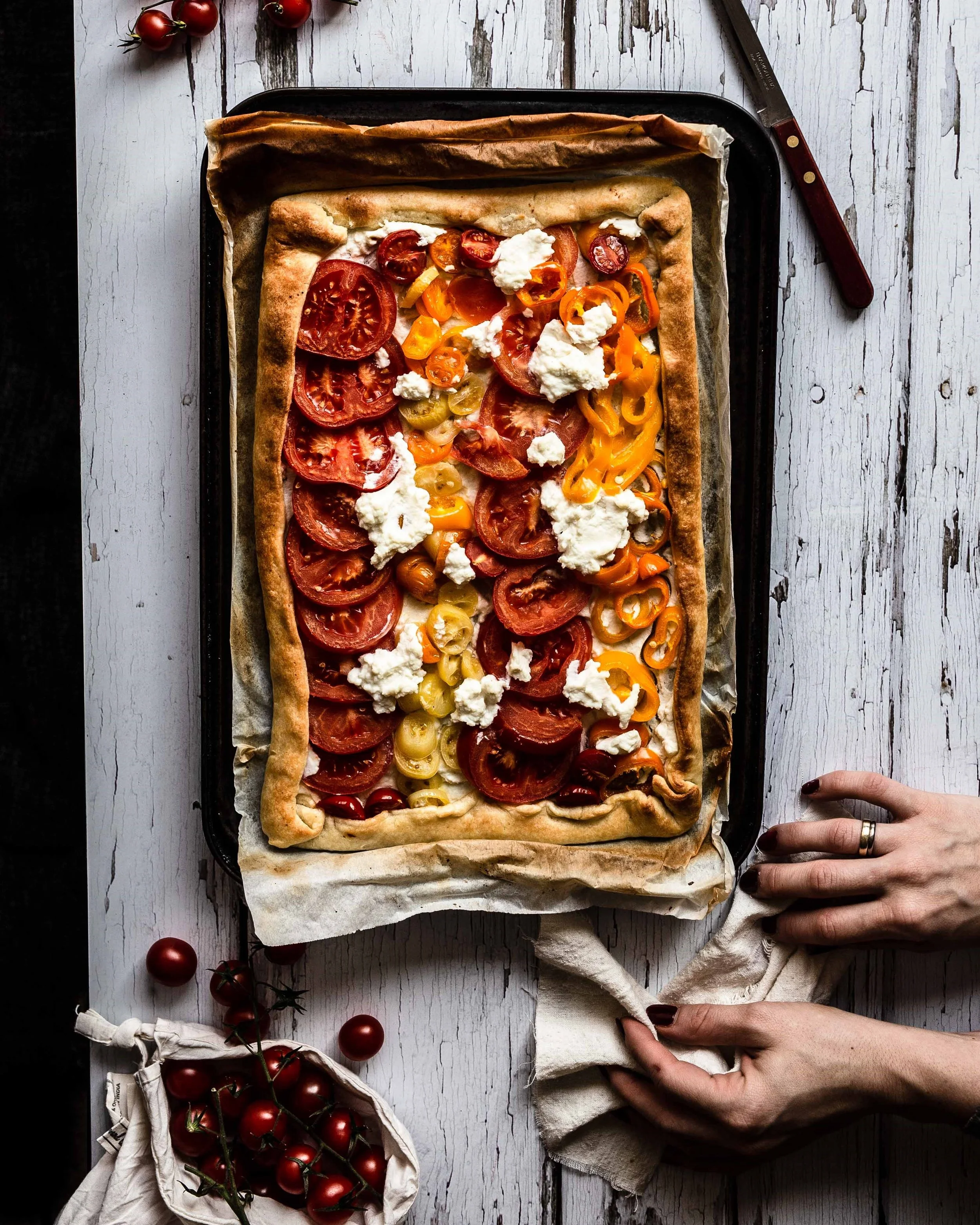 Das Blech ist noch sehr heiß und ein Lappen ist notwendig um die Gemüse Tarte auf den Tisch zustellen.