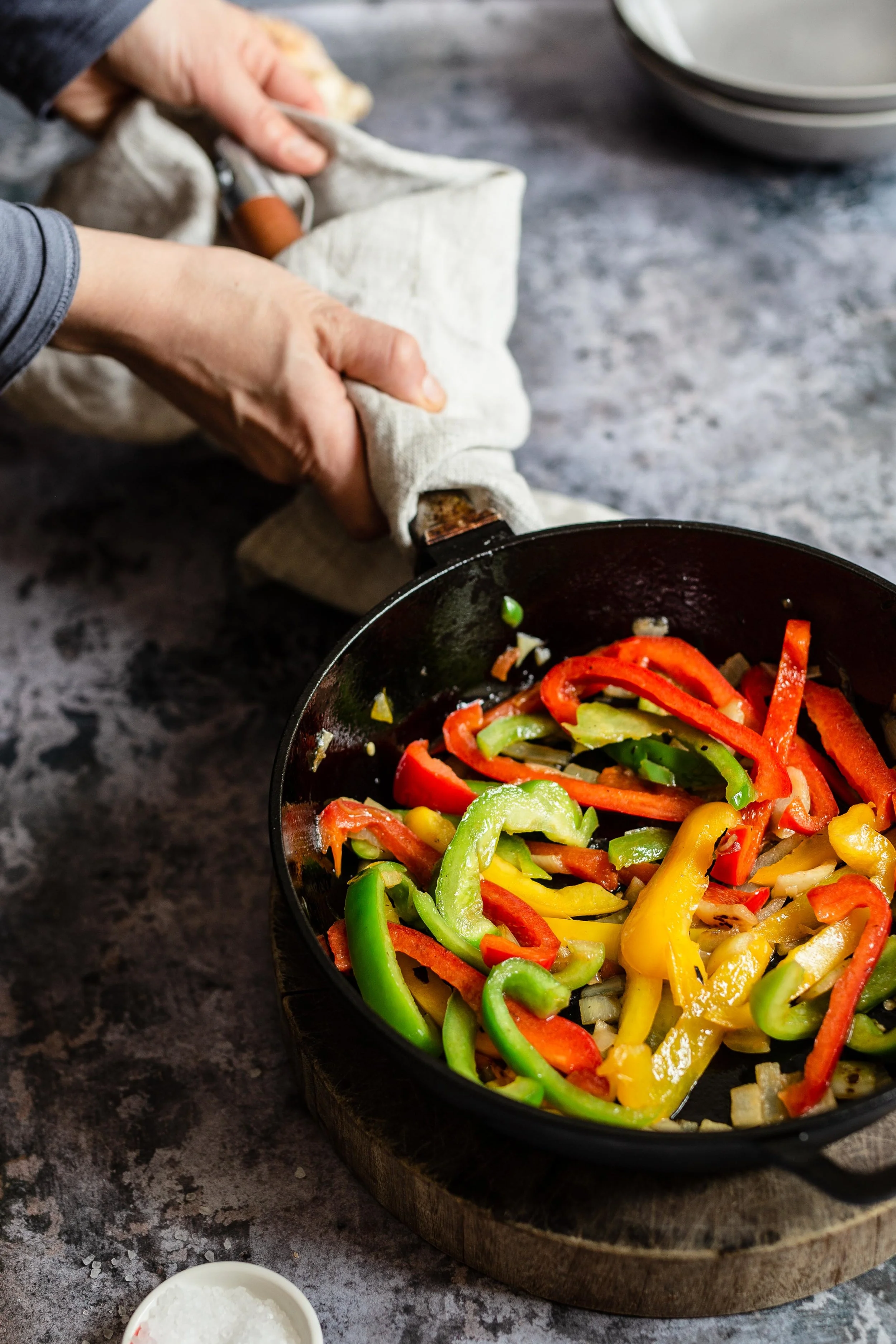 Grundlage für unsere Shakshuka sind bunte Paprika- und Zwiebelstreifen, die wir in der Pfanne andünsten, bis sie etwas weich geworden sind.