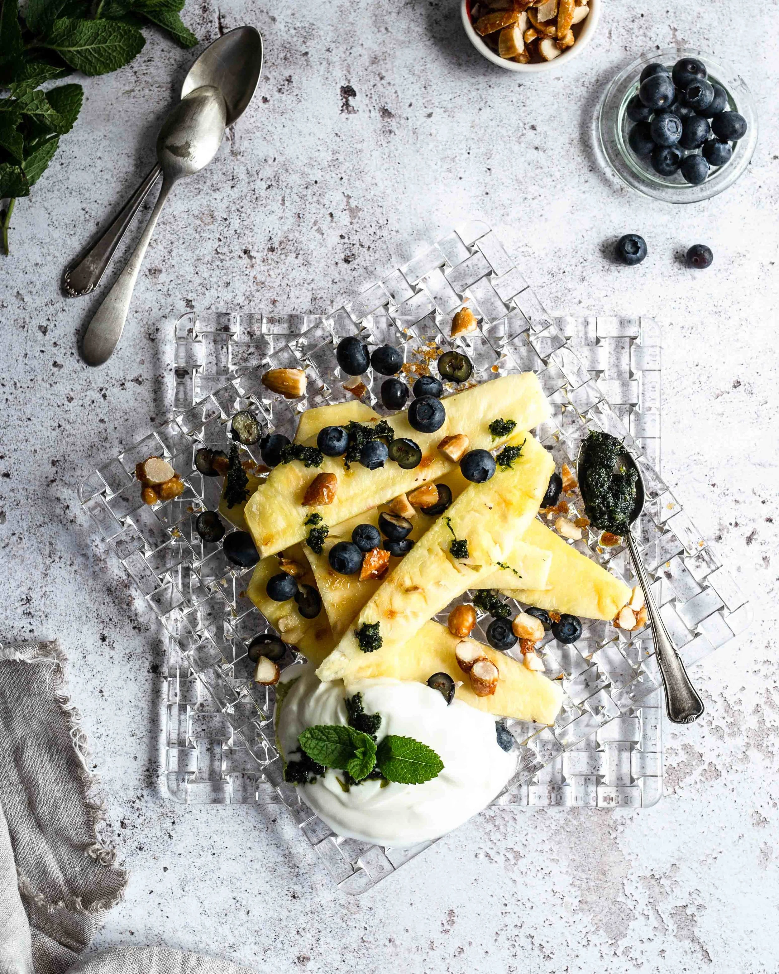 Die Blaubeeren, die kandierten Nüsse und der Minze Zweig am Bildrand erzählen unsere Food Story zu Ende