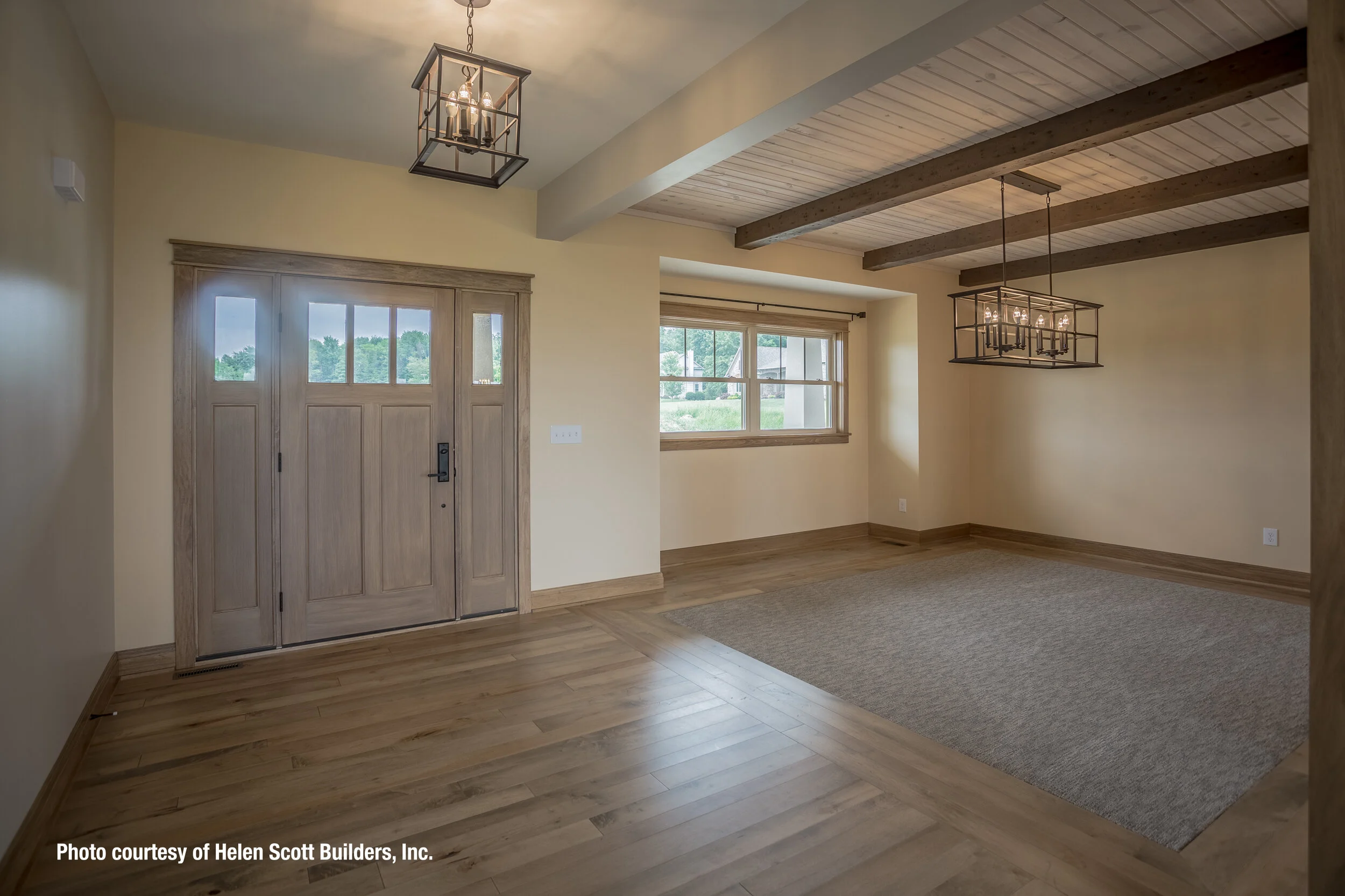 Custom wood ceiling beams compliment hardwood floors and door.