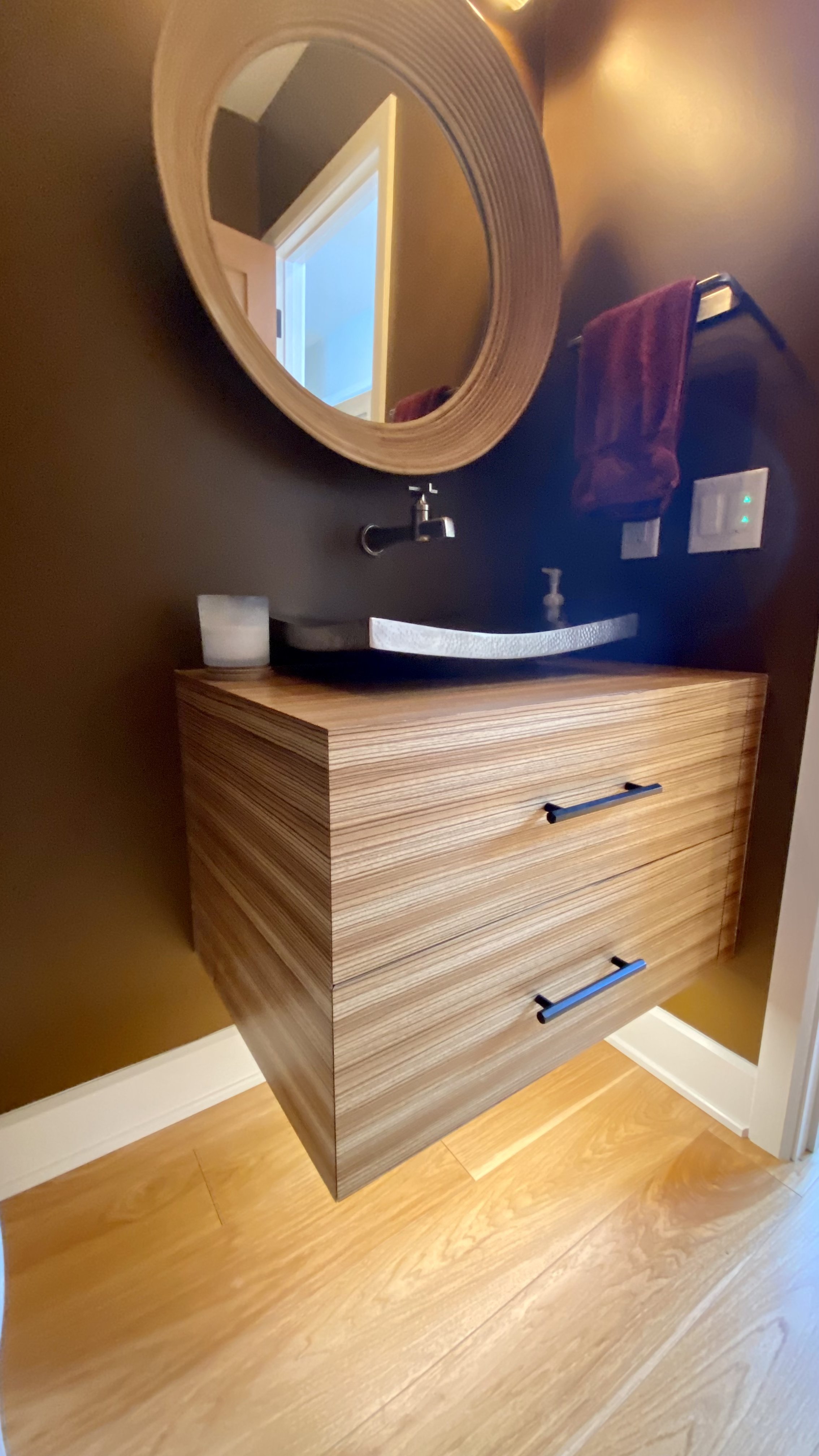 Floating bathroom cabinet and sink with precise zebra wood flitching.