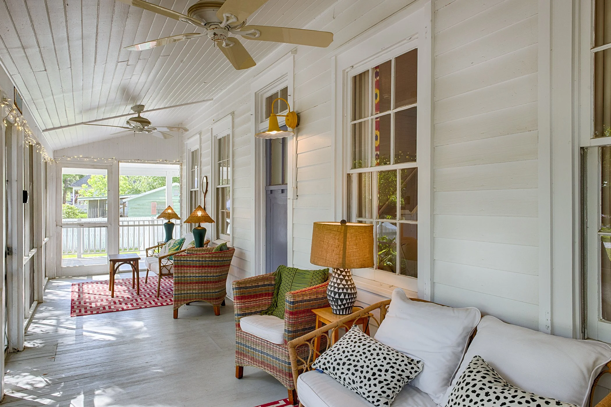 Front porch of Bliss Cottage vacation rental on Tybee Island with covered entry and seating area.