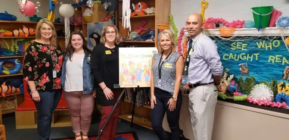 Shea and team posing in front of Bernstein Bear's visit the Credit Union Book.JPG