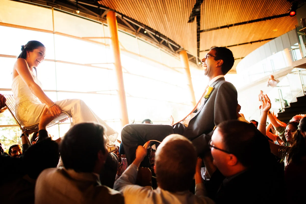 Bride and groom lifted on chairs during a wedding reception at the Arena Stage at The Mead Center, Planning by Bella Notte, Photo by Connor Studios