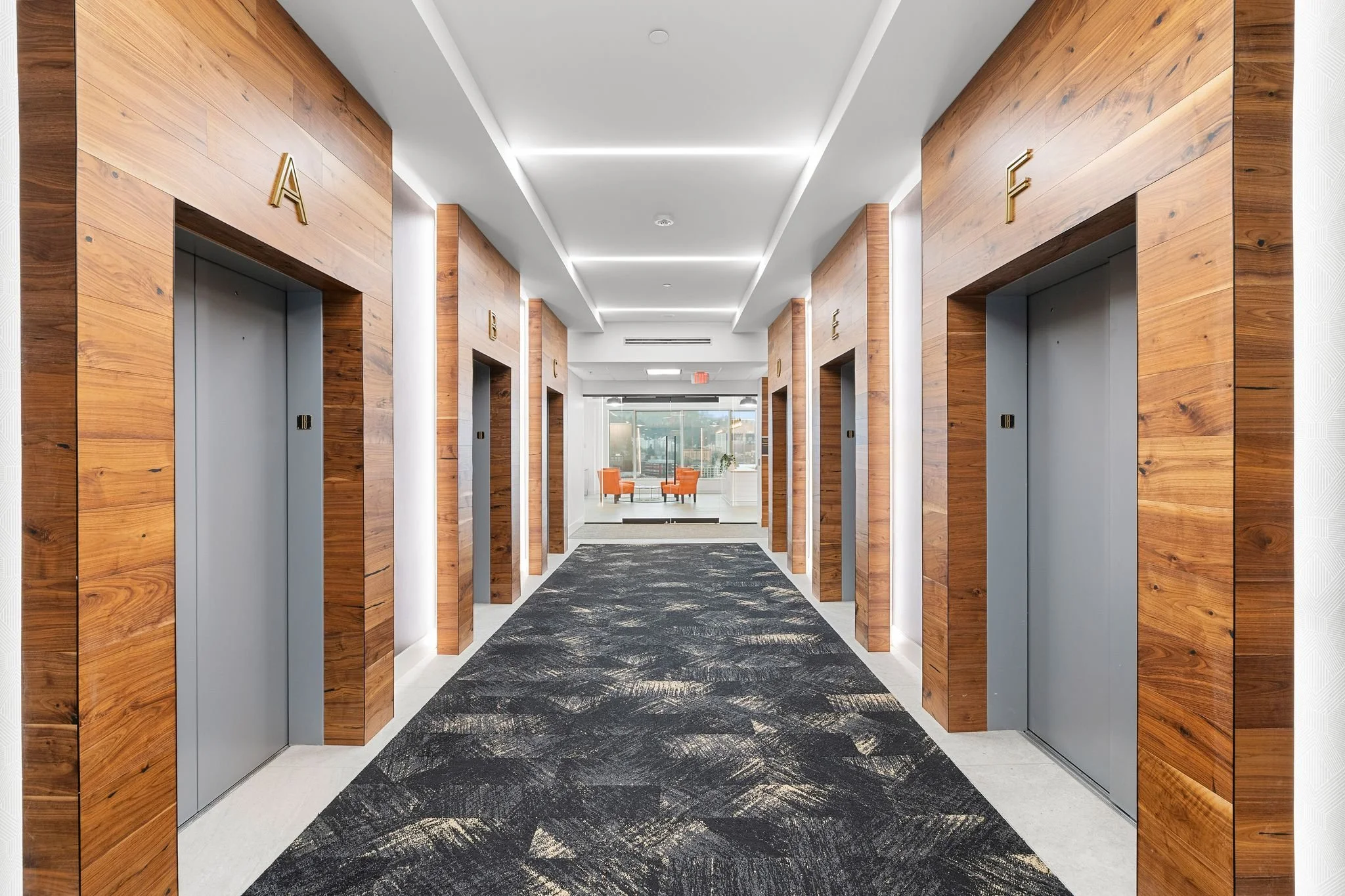 Elevator Hallway with wood accents and gray carpet