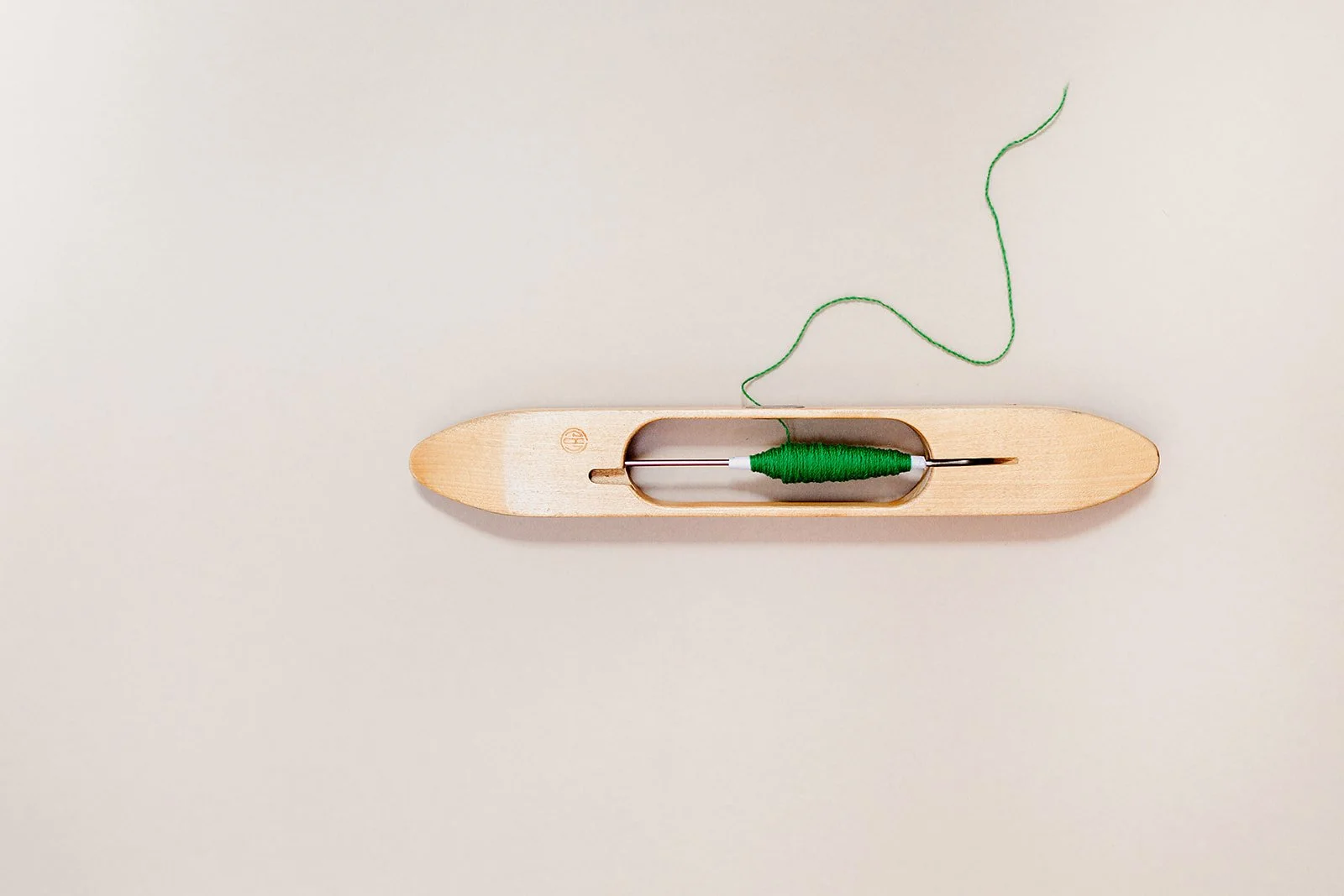 weaving shuttle with green yarn