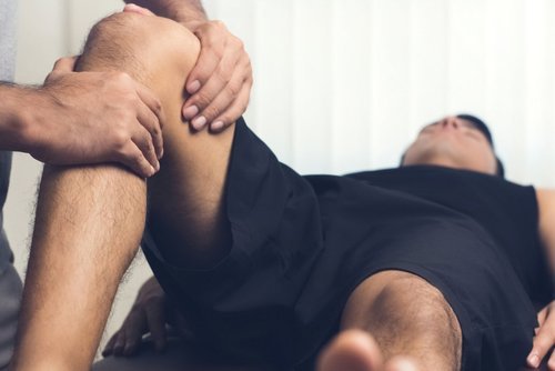 A person receiving physical therapy or massage on their leg from a chiropractor.