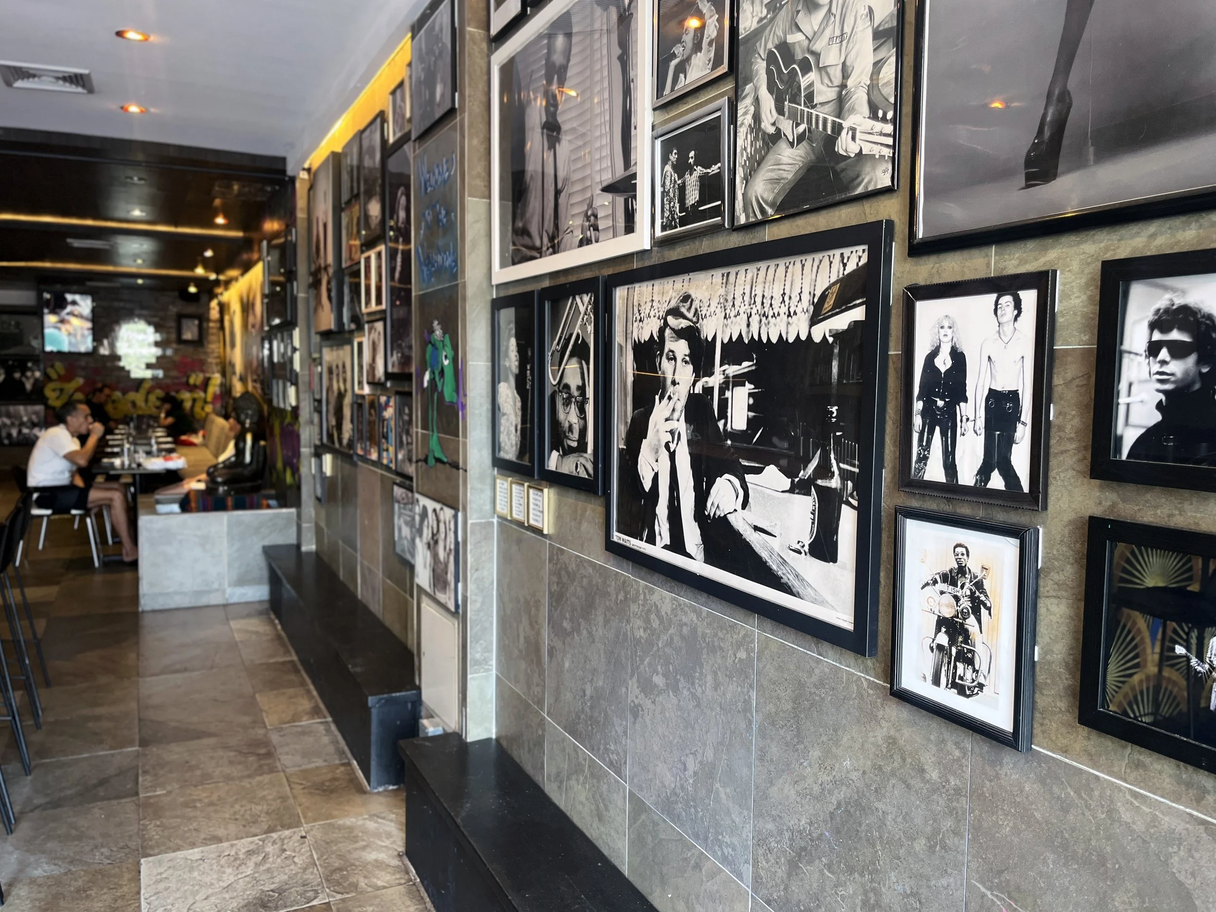 Gallery wall featuring music and New York icons inside Urban Vegan Kitchen, a vegan restaurant and cocktail bar in Chelsea, NYC.