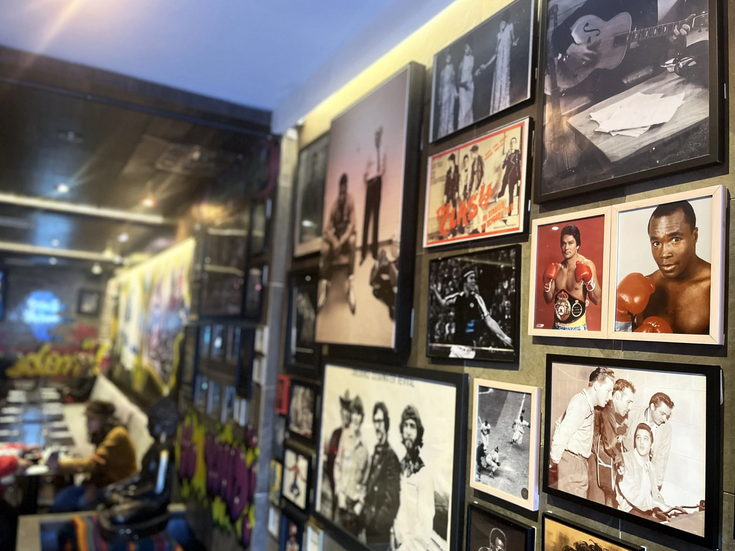 Framed portraits of boxers on the wall at Urban Vegan Kitchen, with the Chelsea dining room in the background.