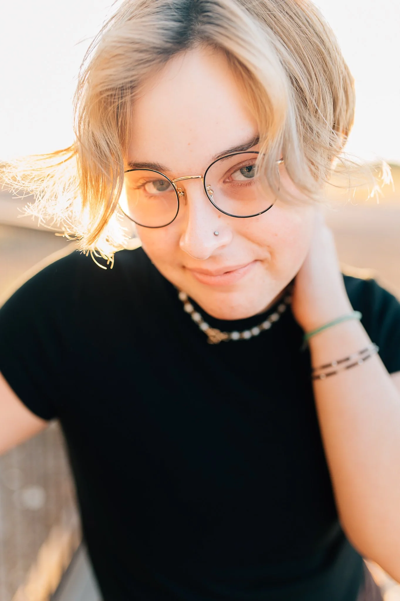 Senior boy in black shirt and glasses looking at camera