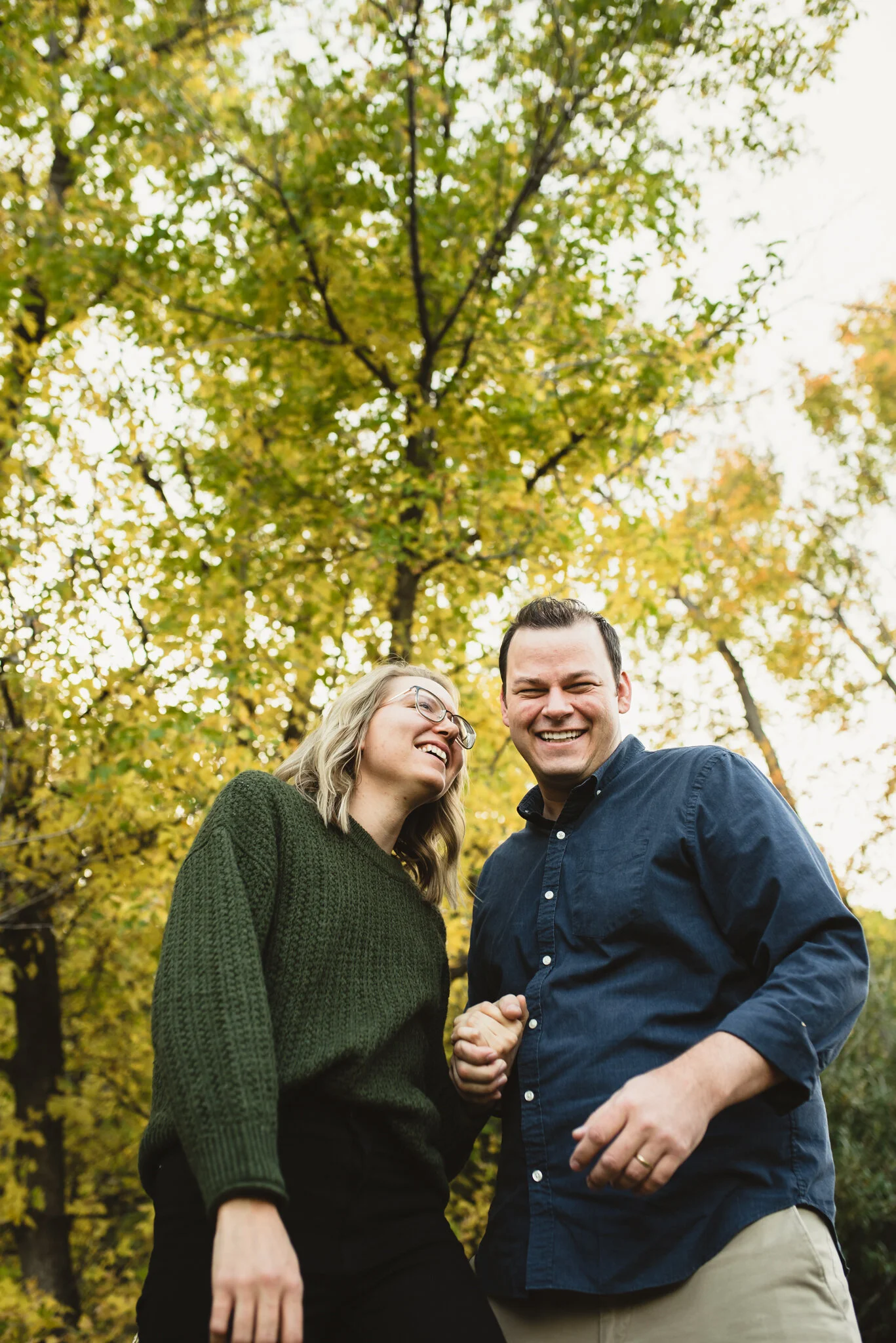 Couple holding hands in front of yellow leaves in Sandia Mountains, Albuquerque