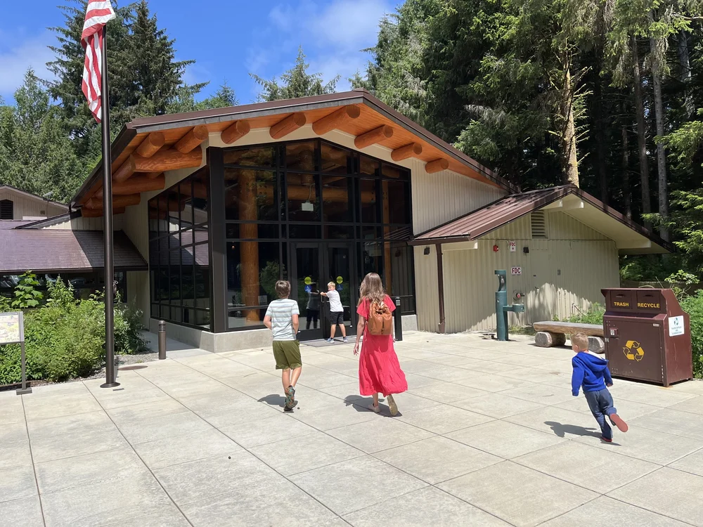 Woman in pink dress and three boys walking into Lewis and Clark NHS