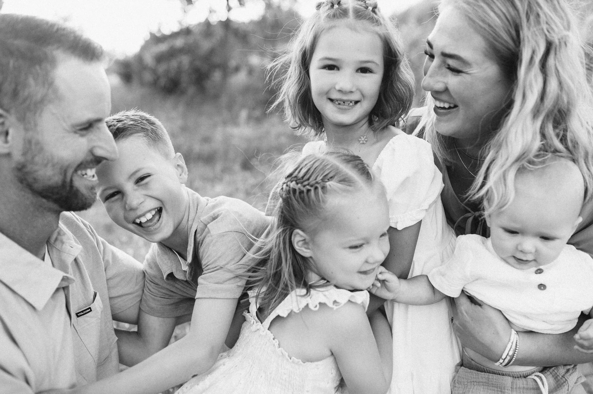 Family with four kids all sitting and laughing together
