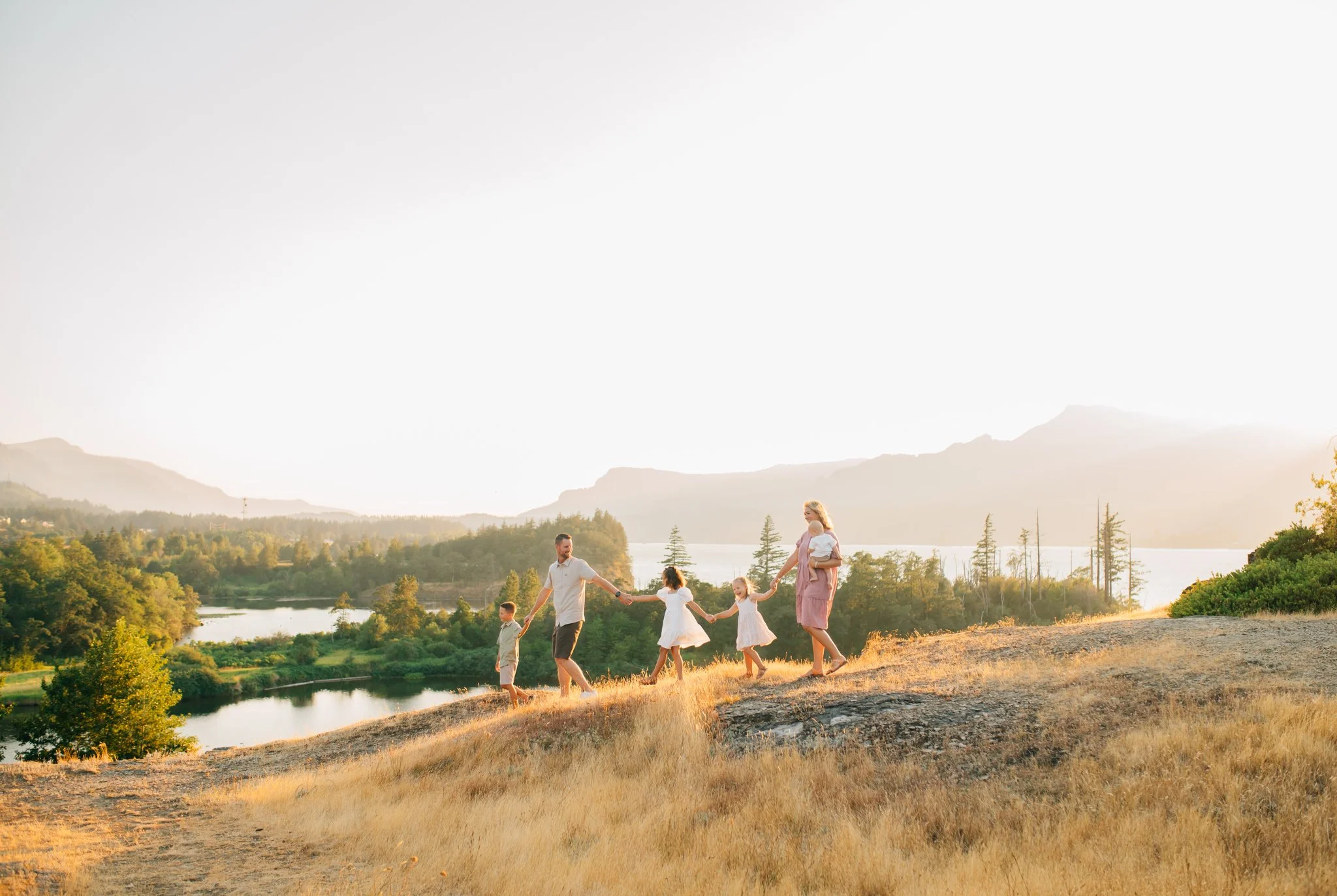 Family holding hands and walking downhill in Columbia River Gorge