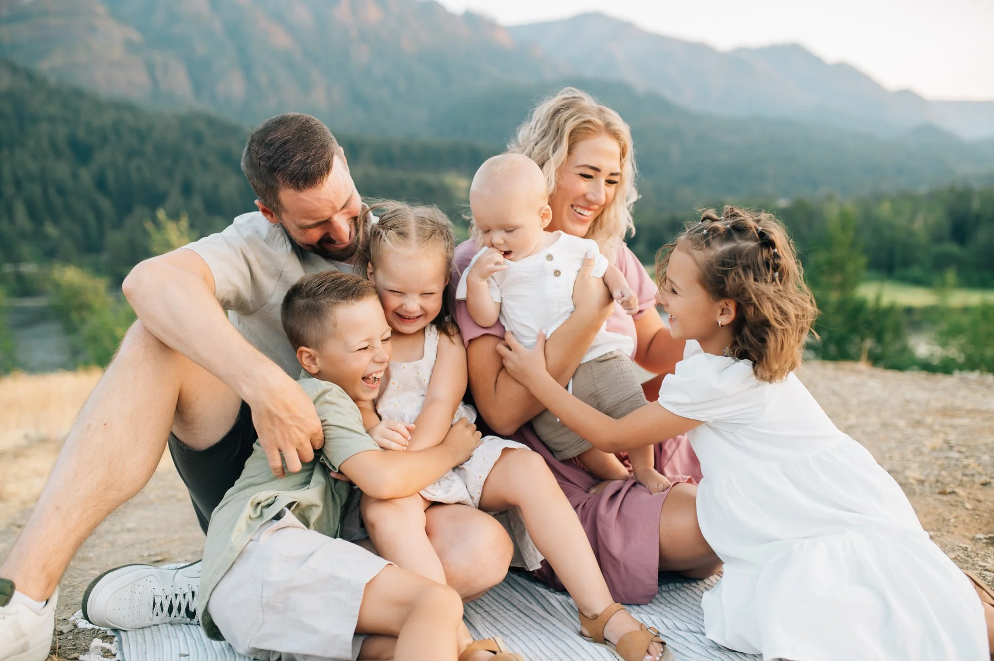 Family sitting together and snuggling in Columbia River Gorge