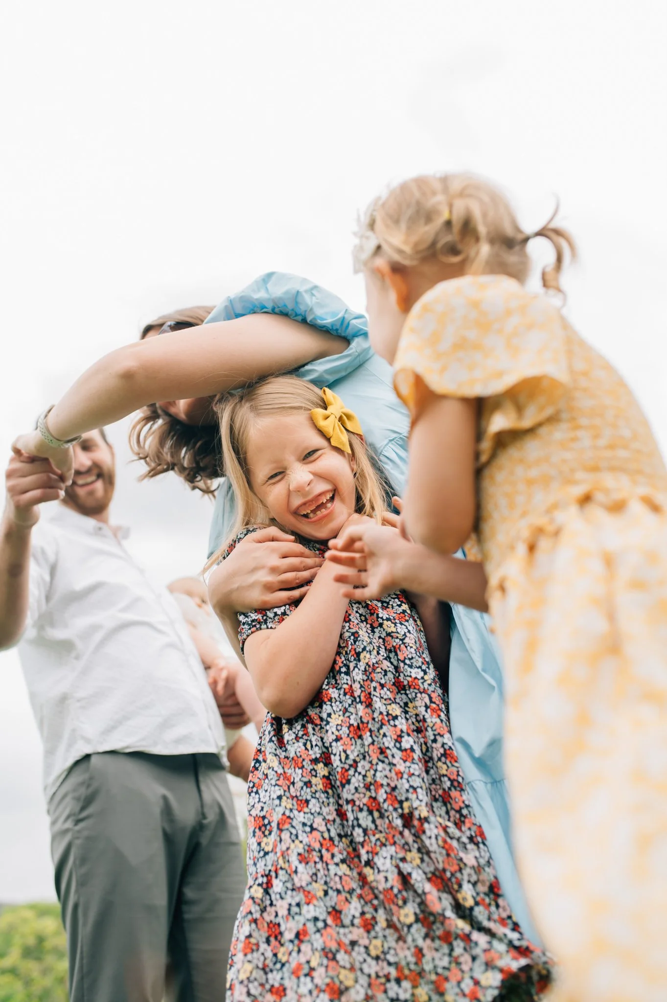 Little girl laughing at camera as parents try to catch her
