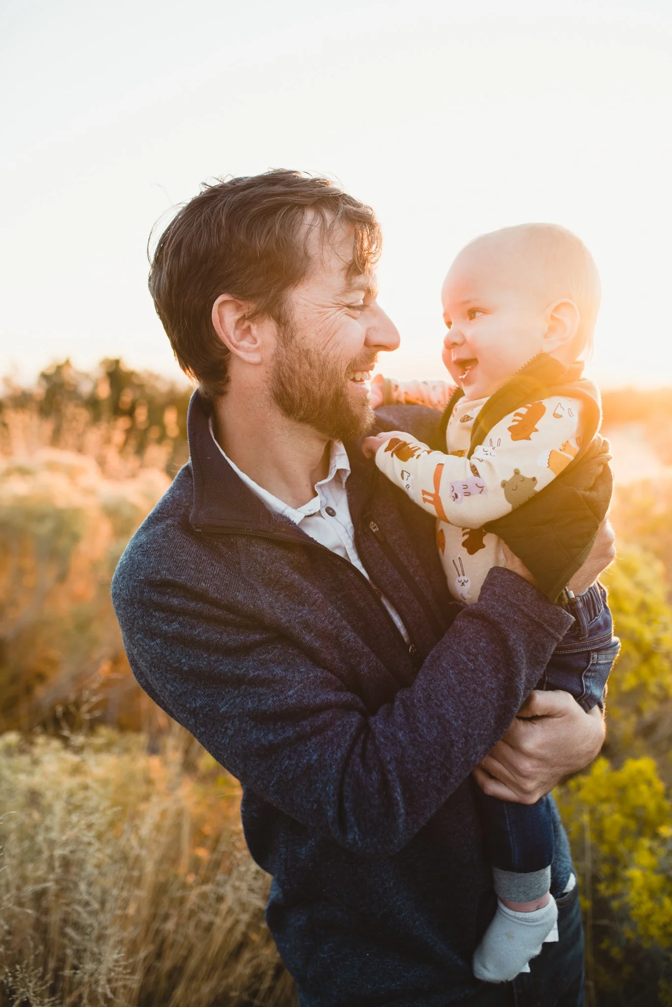 Dad holds baby as they smile at each other