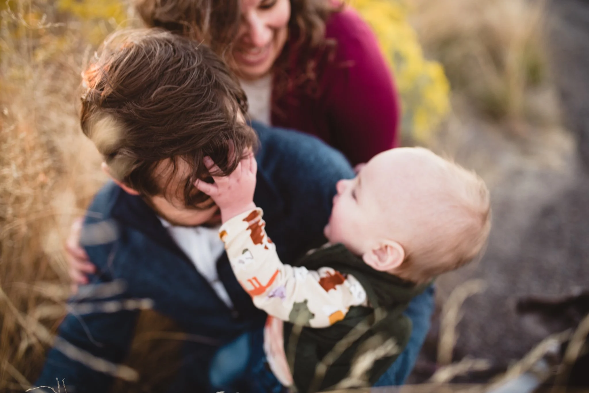 Baby reaching for dad's hair as they play together