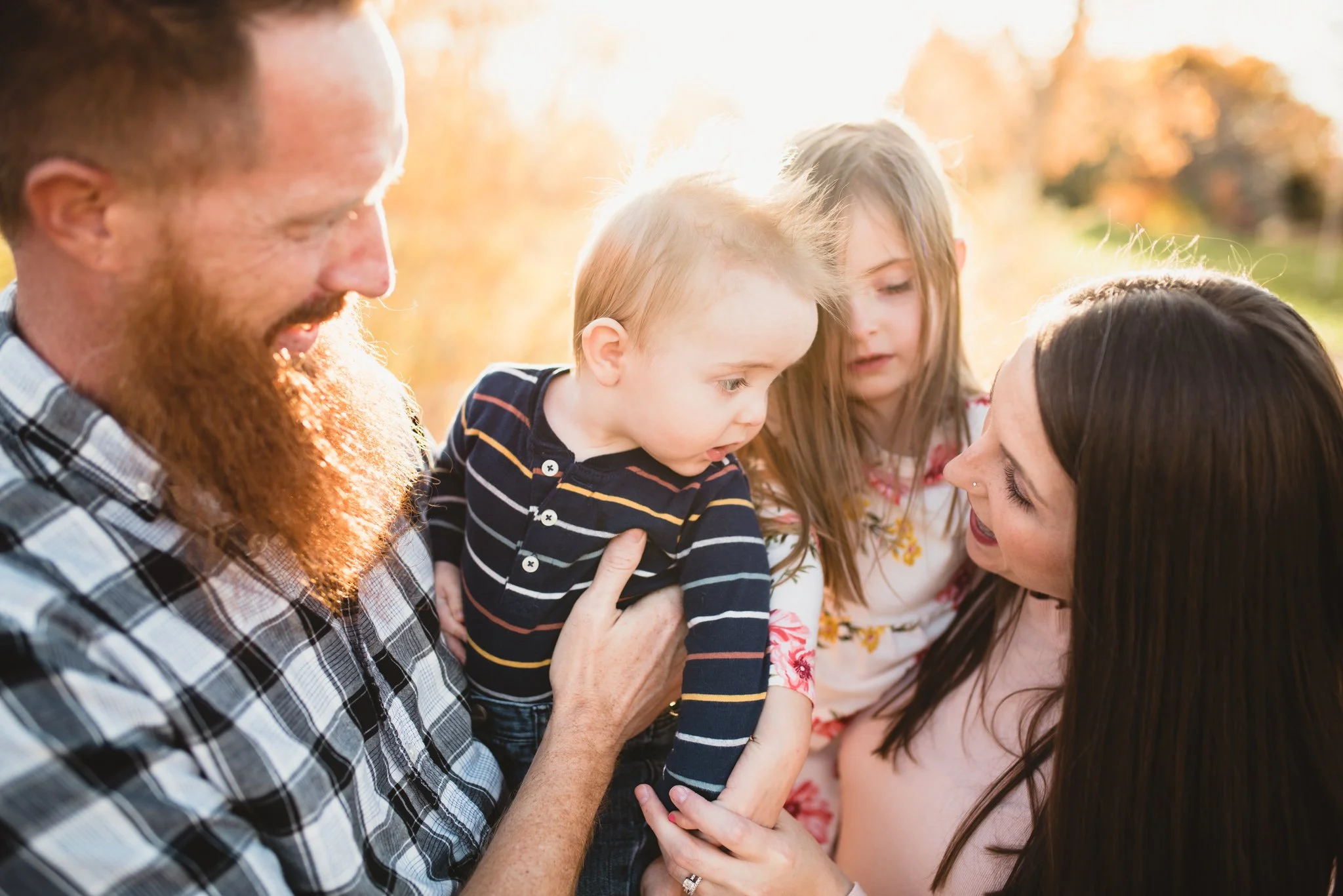 Parents hold their son and daughter in between them as they look at each other