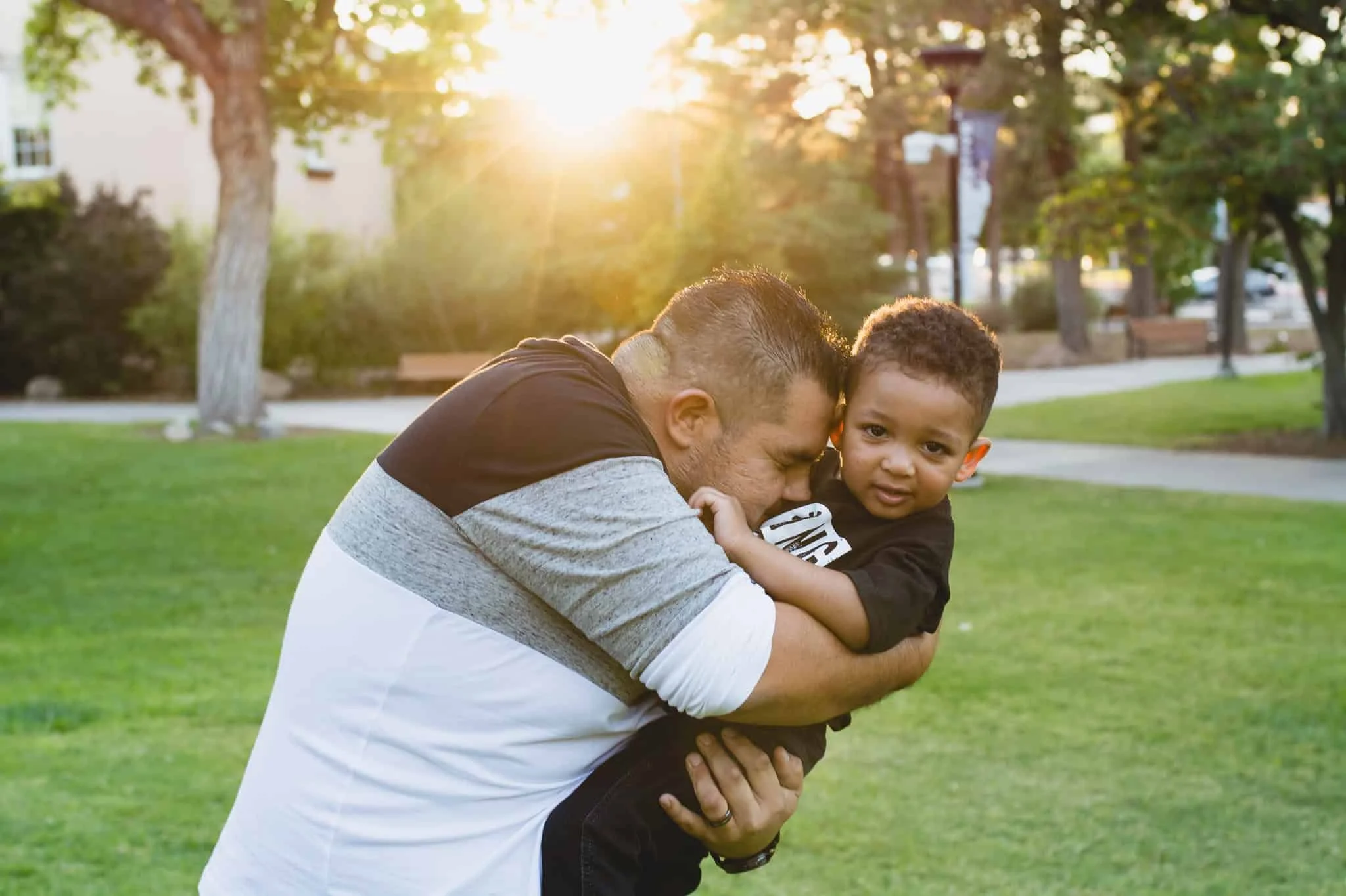 Dad leaning into and hugging his little boy
