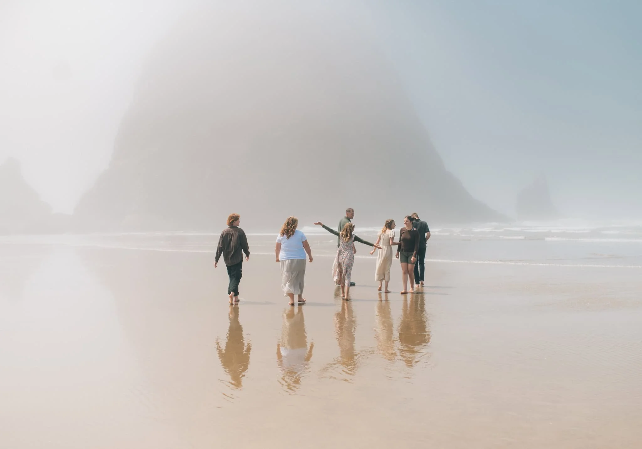 Family walking towards giant rock at Cannon Beach