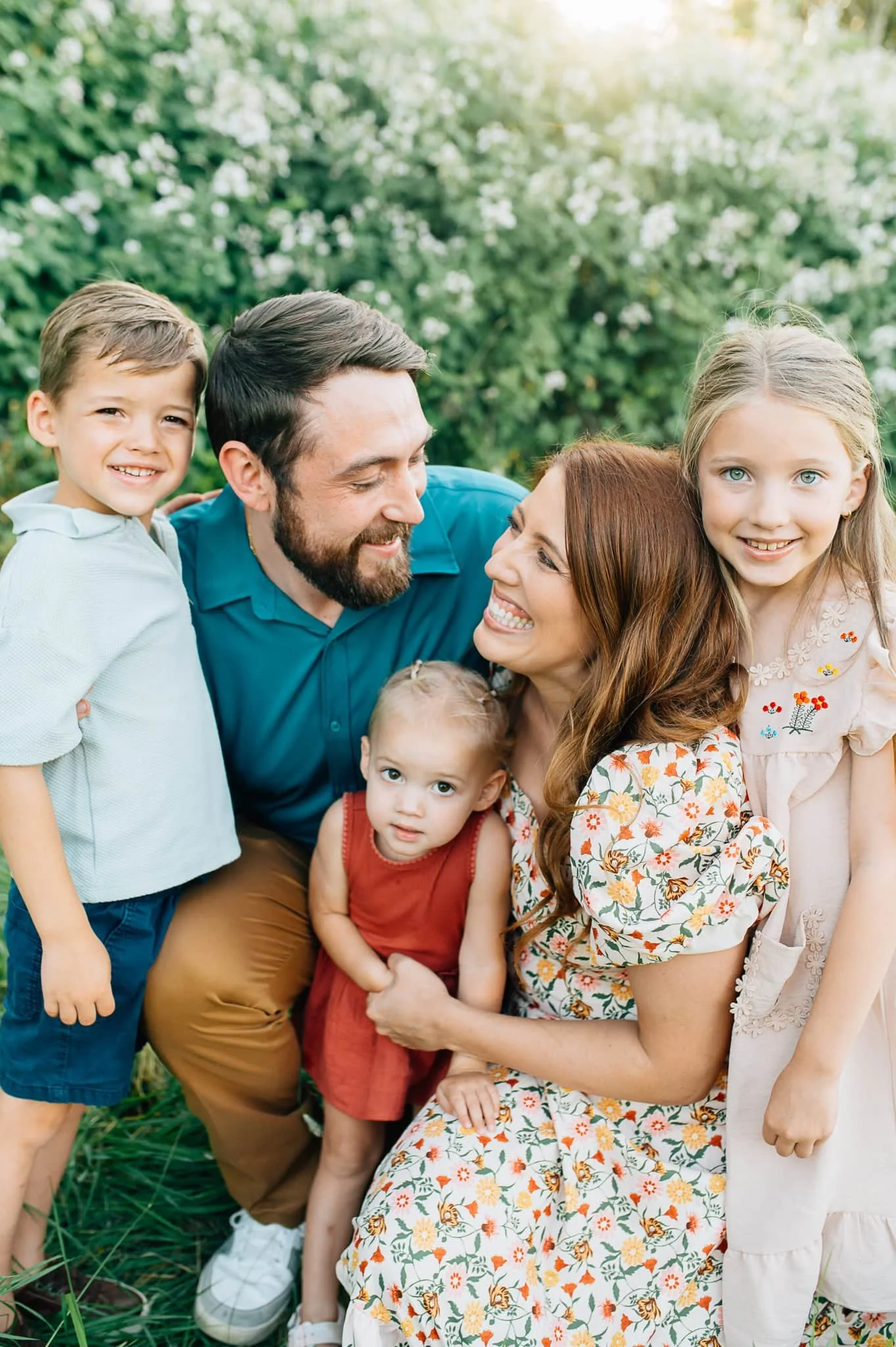 Mom and Dad kneel while kids surround them and hug them