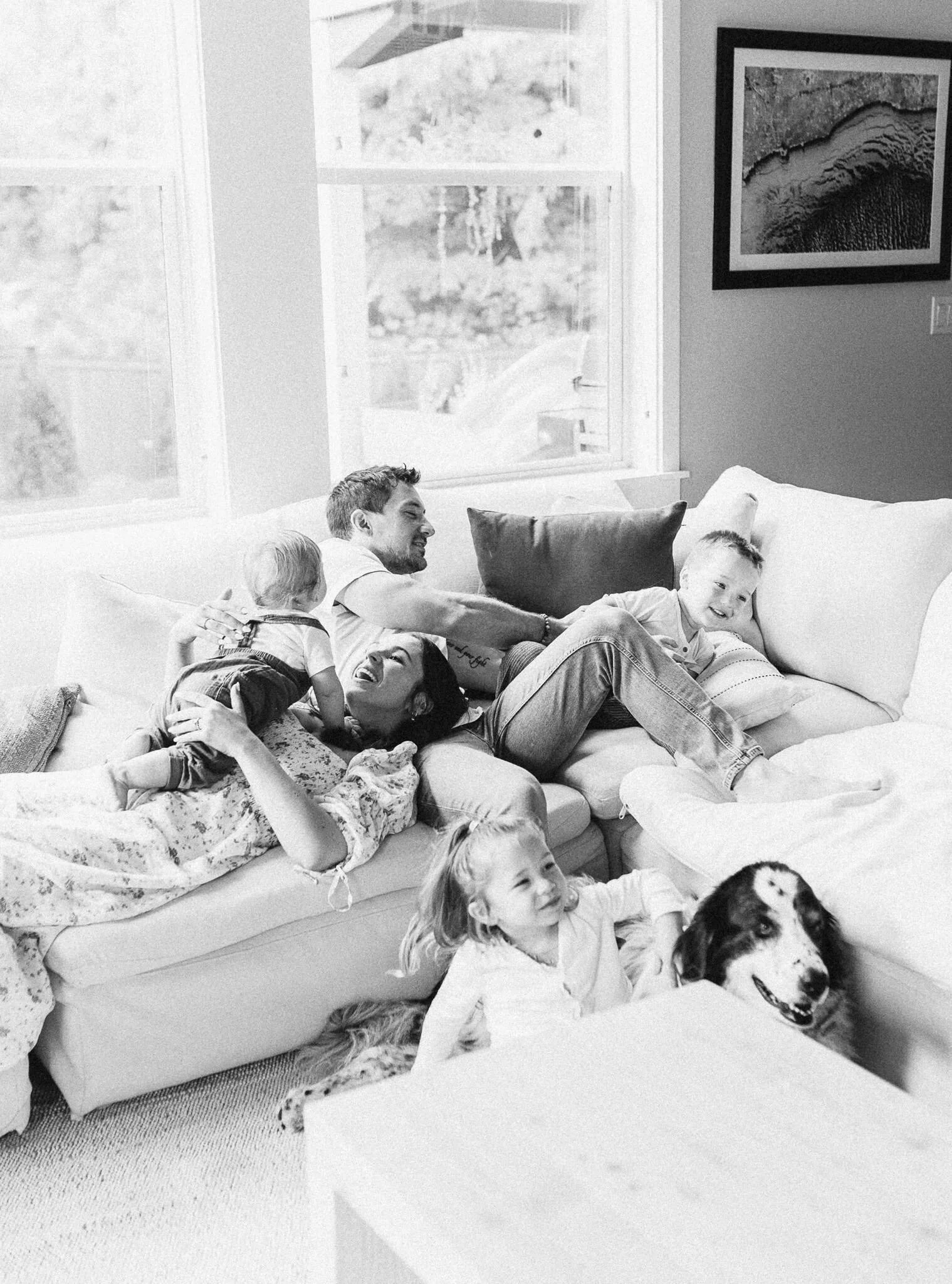 family laying and playing on couch in their home