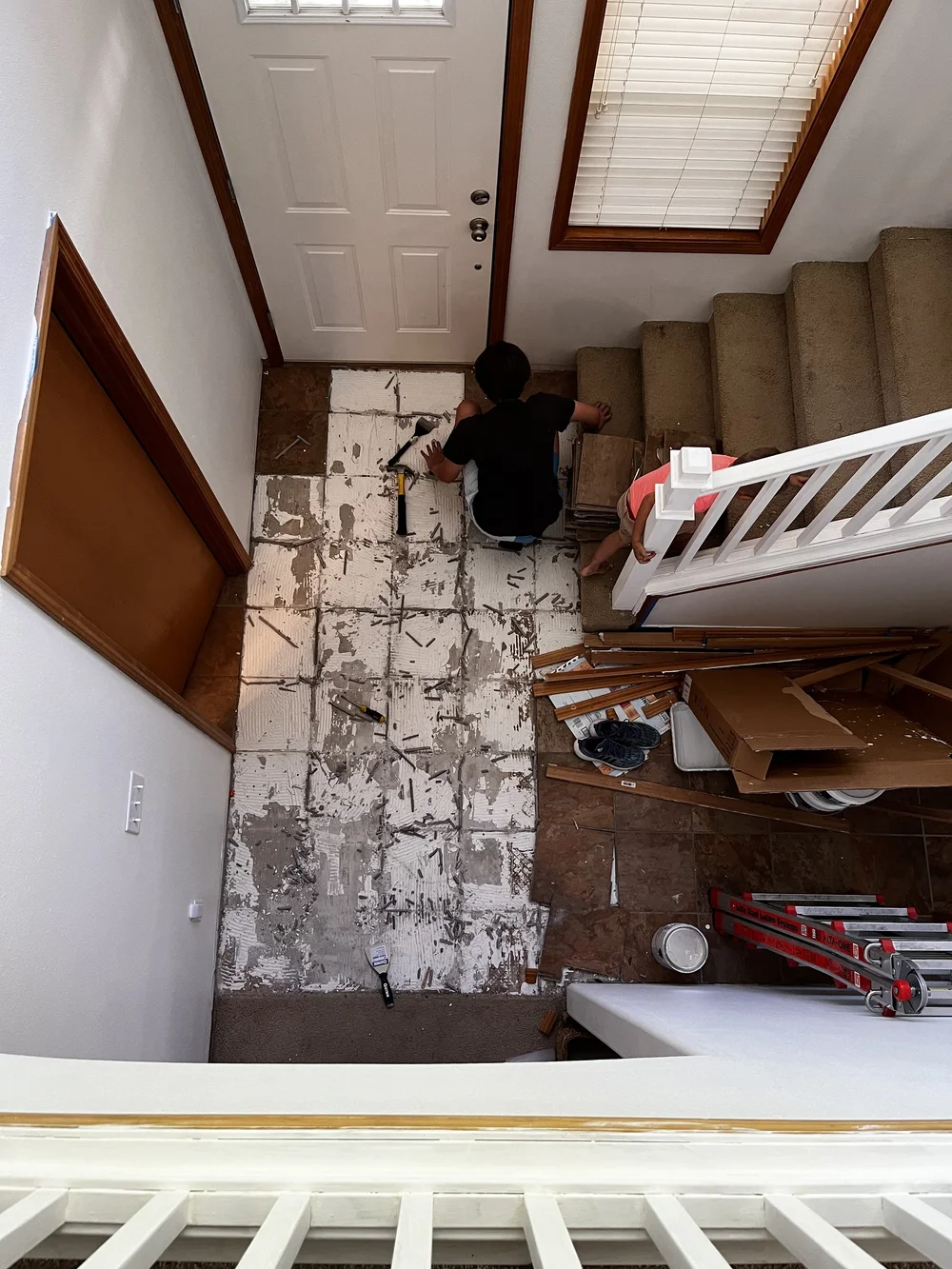 Tearing up the brown square tile in the entrway