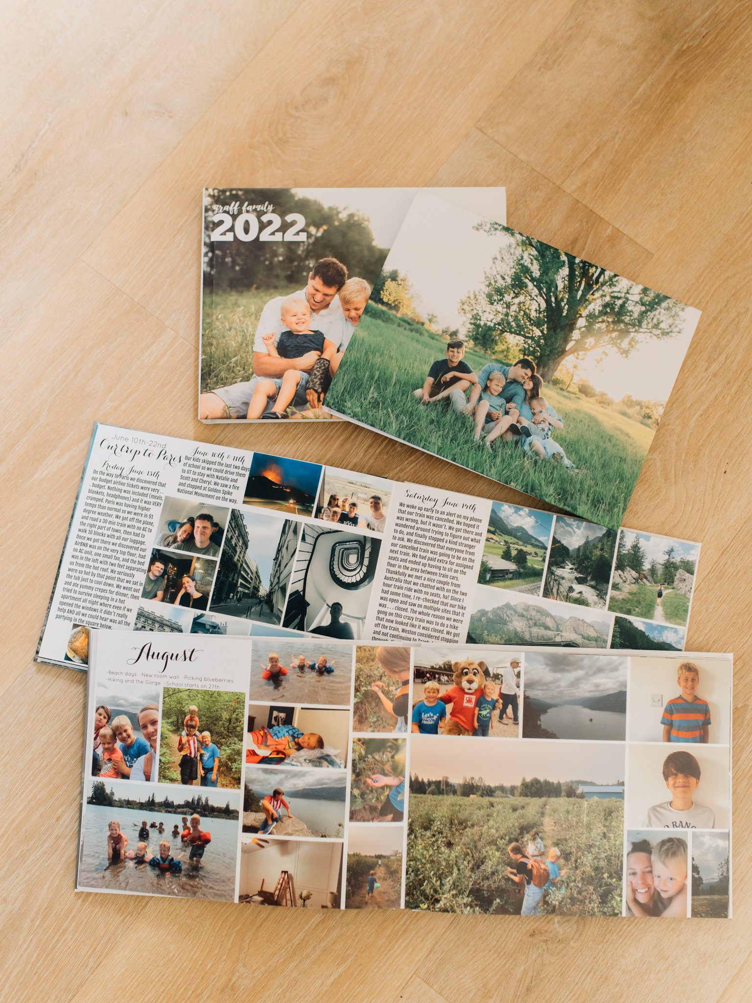 Multiple family photo books laid out on the floor, two are open and display photos and text
