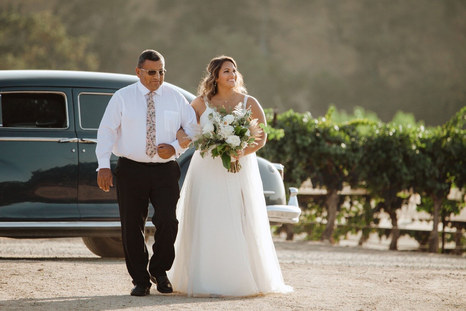 Bride and her father walk down the aisle in the vineyard at her Cass Winery Wedding. Slo wedding photography