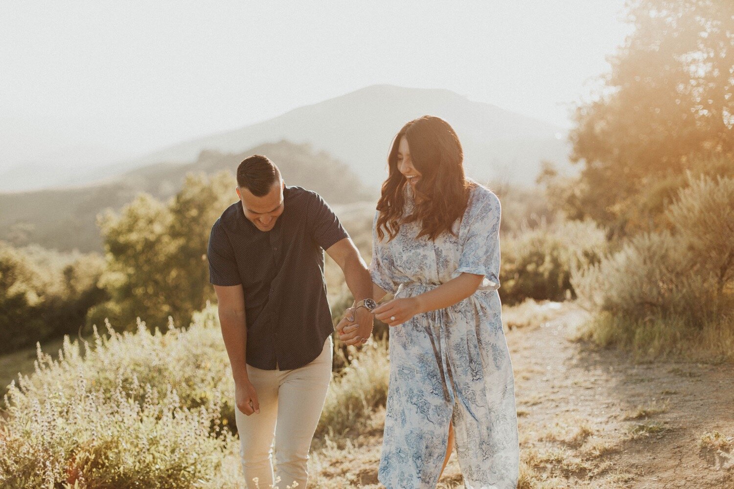 couple laughs while walking together during their golden hour paso robles engagement session. san luis obispo couples photographer