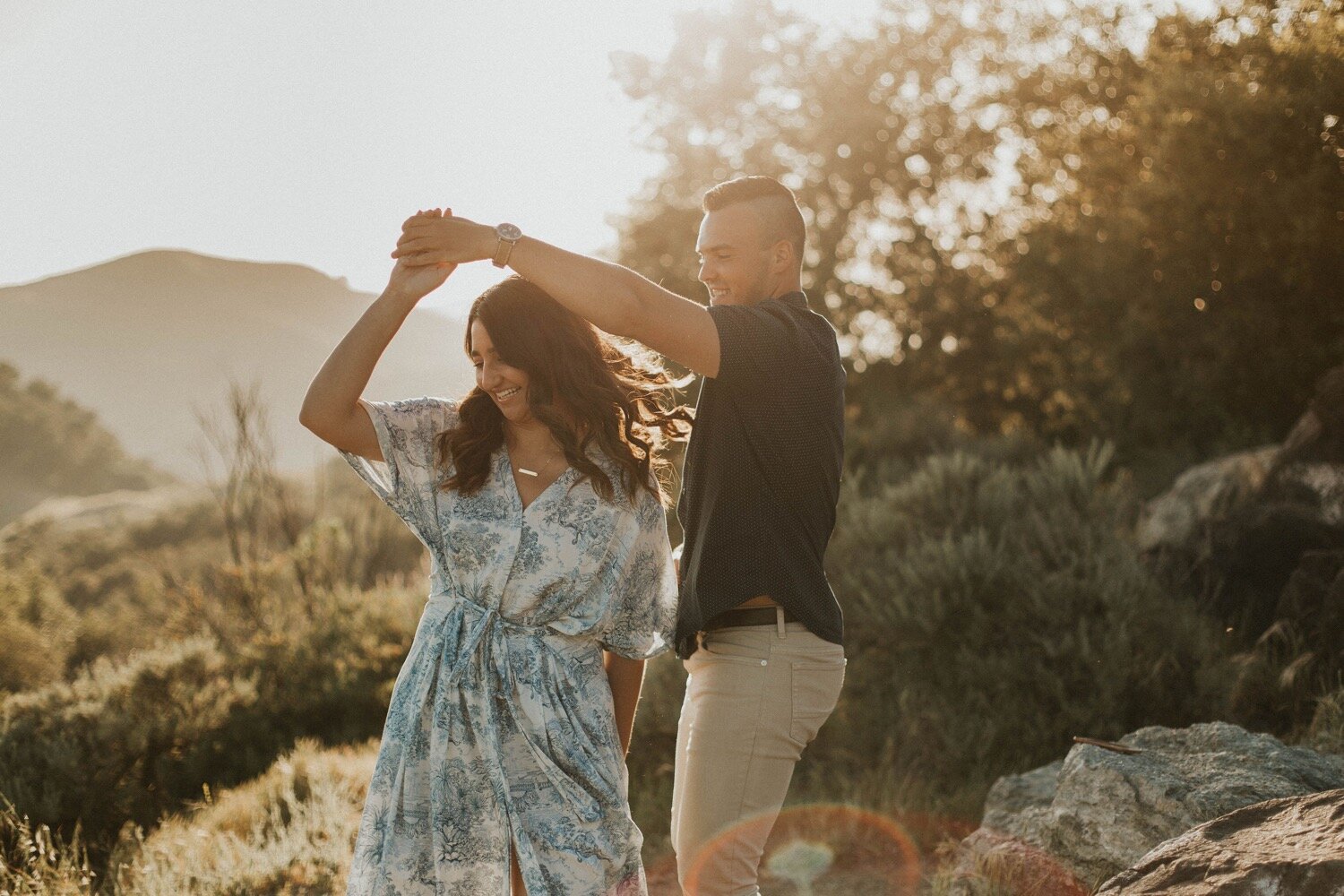 groom twirls his bride as the sun sets behind them in paso robles california during their engagement photos. slo couples photographer