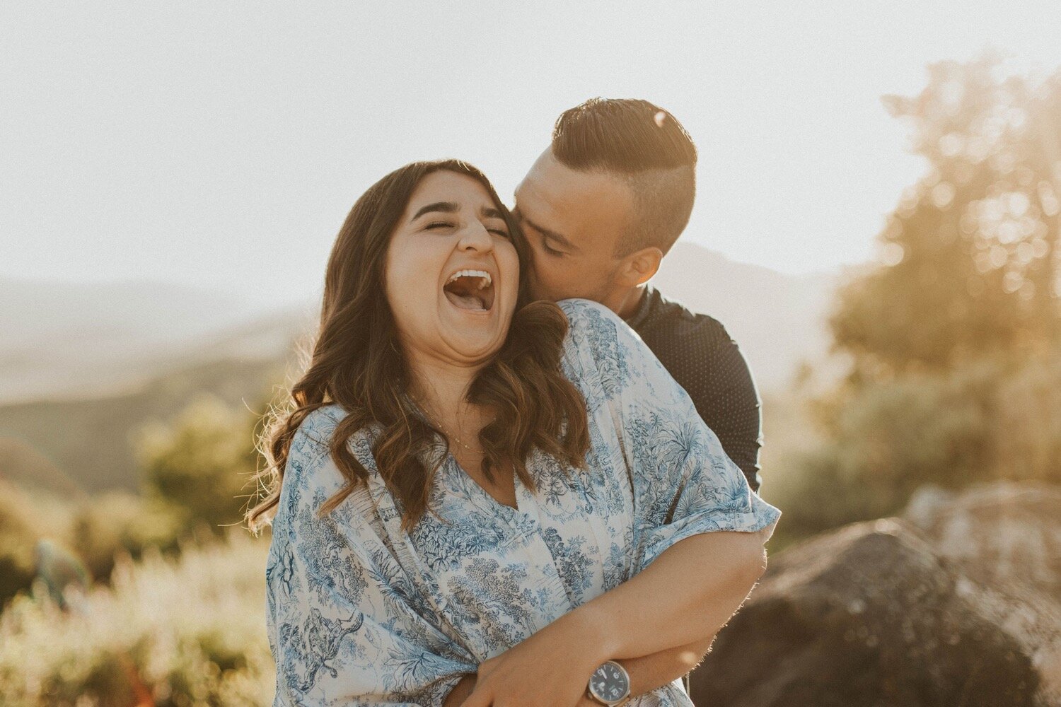 groom kisses bride's head as she laughs during their sunset paso robles engagement photoshoot. paso robles couple photographer