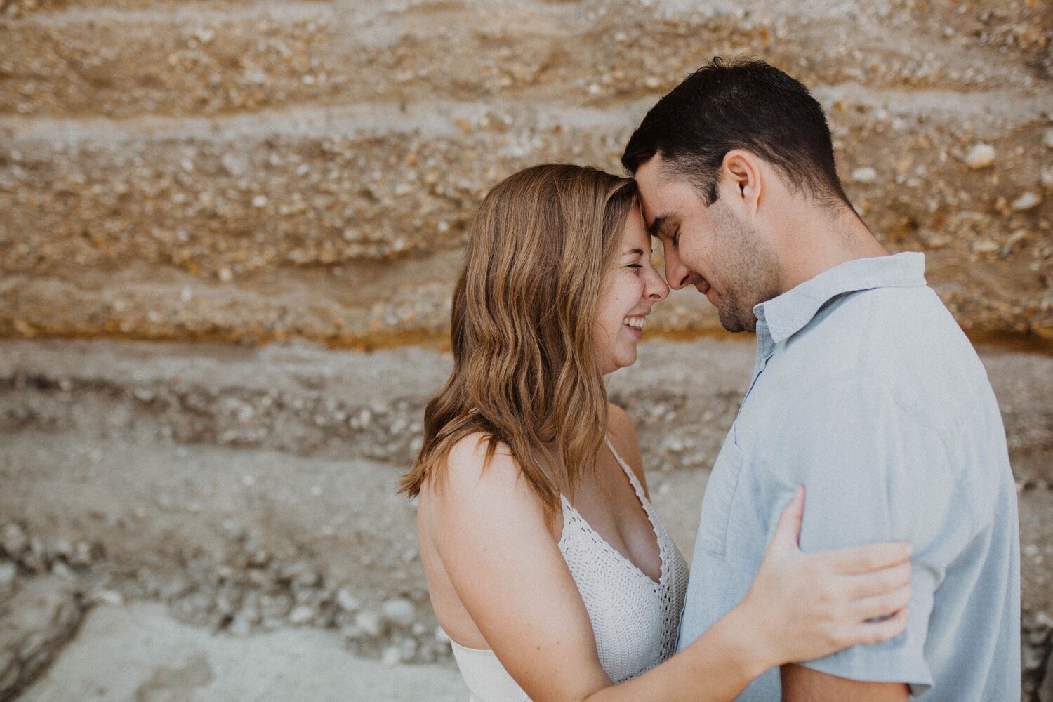couple puts their heads together romantically during their engagement shoot at montana de oro. slo engagement photographer