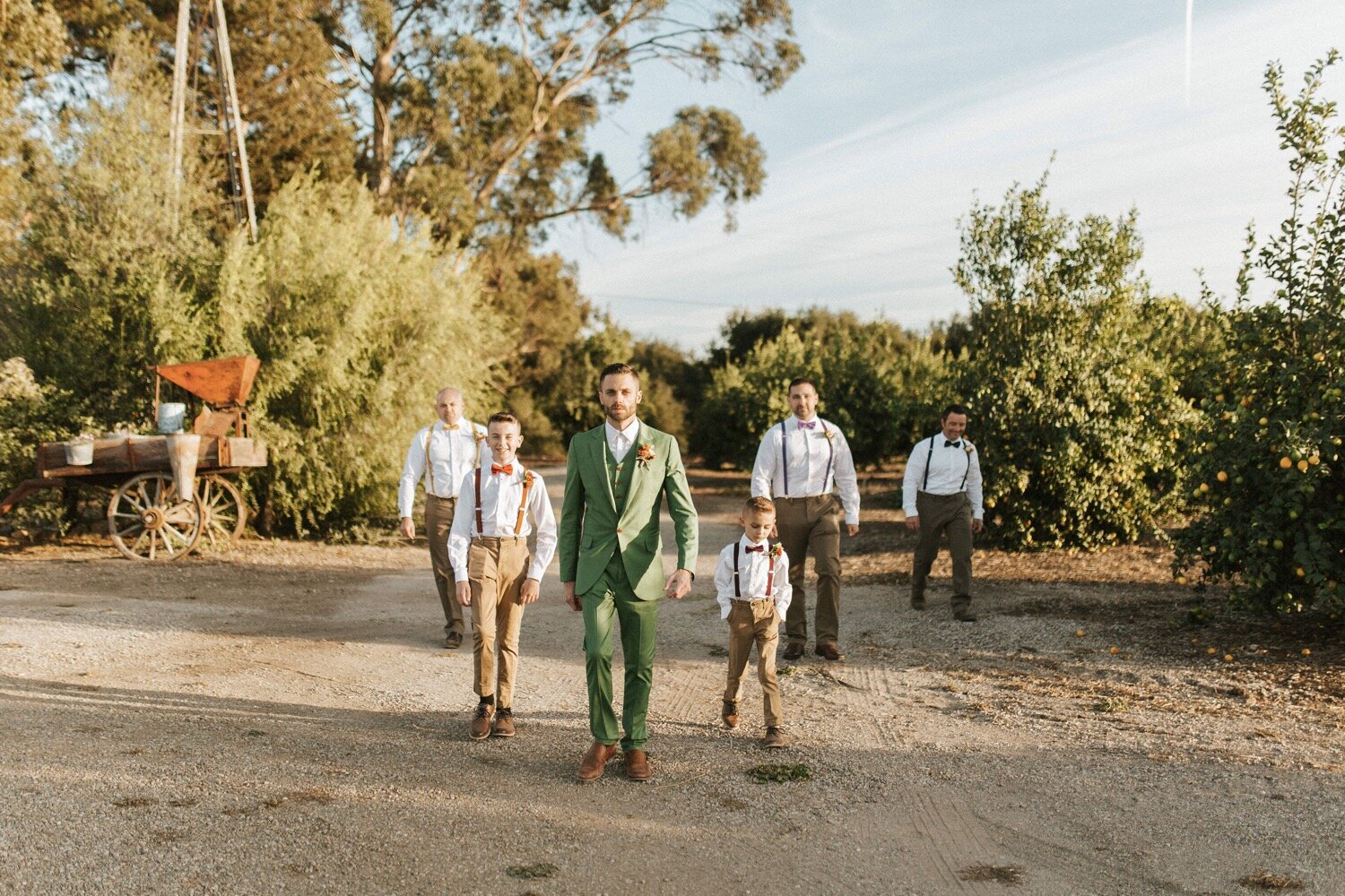  groom and his groomsmen walk around the vintage displays at the dana powers house in nipomo. the groom wore a green suit for his fall wedding, captured by slo wedding photographer poppy and vine 