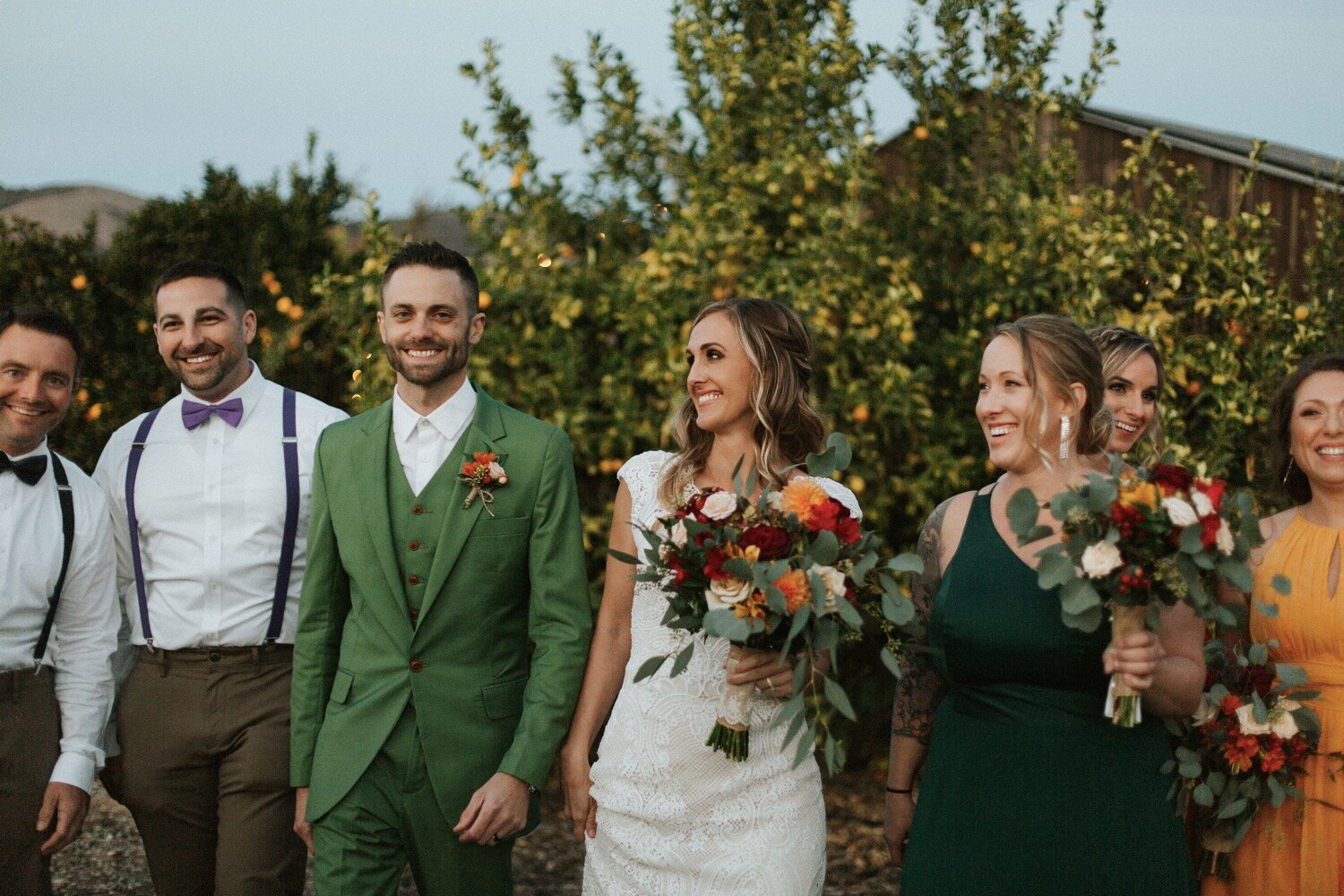  bride, groom, and bridal party, decked out in fall jewel tones, walks around the rustic property at dana powers house, photographed by slo wedding photography duo poppy and vine 