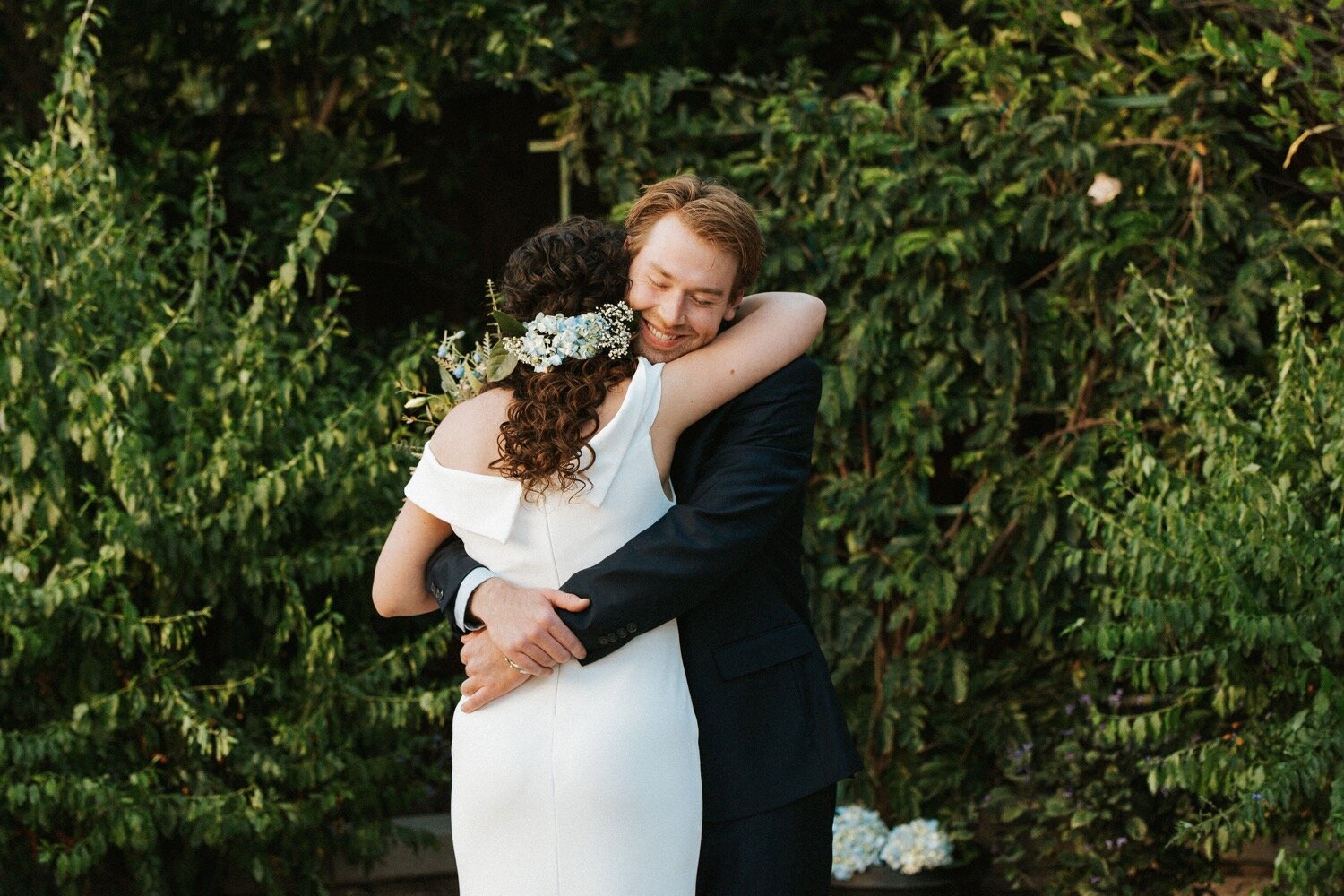  groom hugs bride during their first look at their backyard elopement in Westlake Village, California, photographed by SLO Wedding photographer Poppy and Vine 