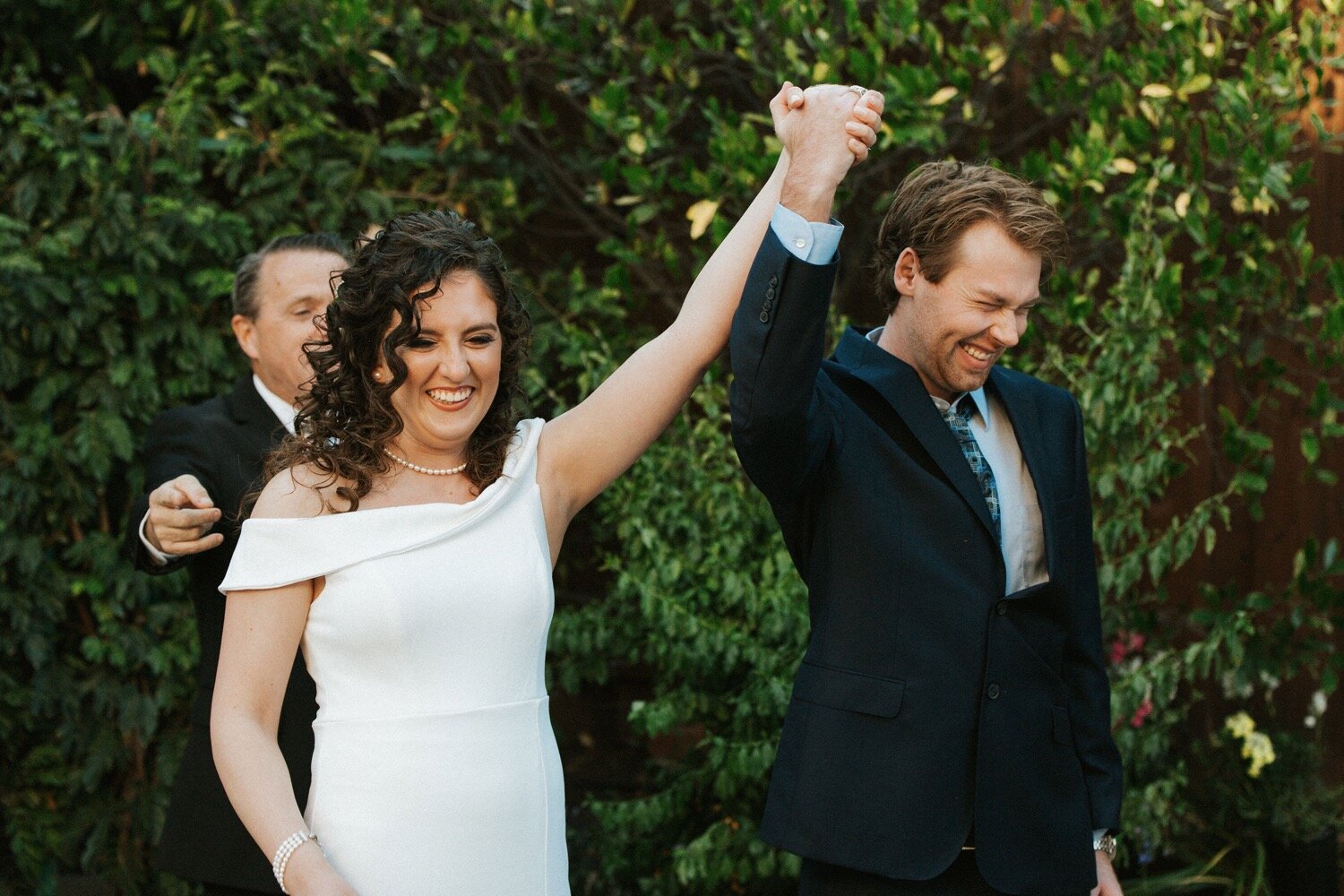  bride and groom are elated after being pronounced husband and wife in an intimate backyard wedding ceremony in los angeles california. central coast wedding photography duo poppy and vine captured the moment 