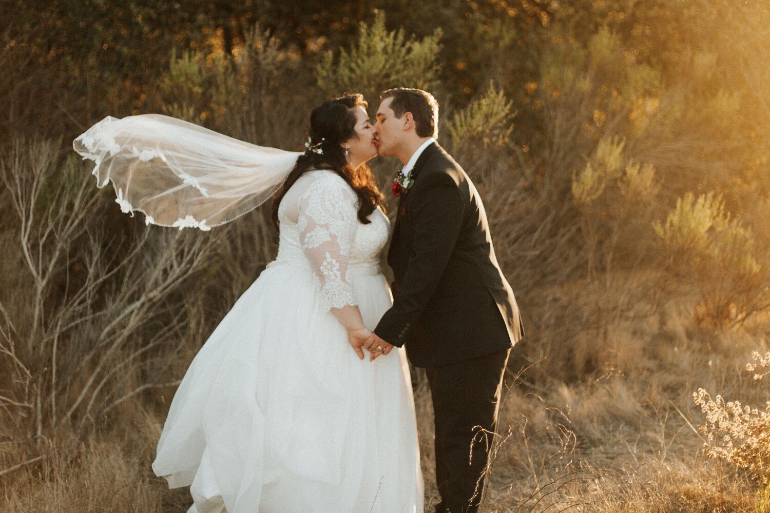  bride and groom kiss as bride’s veil billows gracefully in the wind during their nipomo wedding, captured by slo wedding photographer poppy and vine 