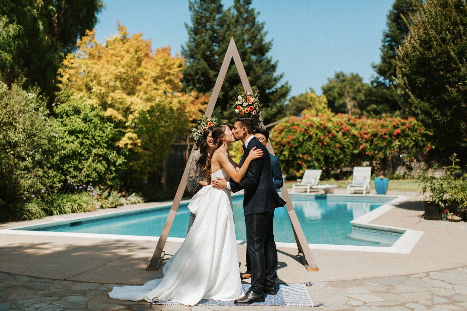  bride and groom exchange their first kiss as husband and wife during their backyard wedding ceremony in los gatos, captured by california wedding photographer poppy and vine 