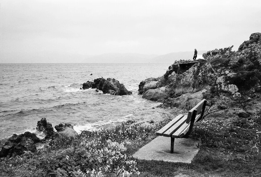 Ilford HP5 Plus - Around the Bays - Bench with a view of the sea boy playing in the background.jpg
